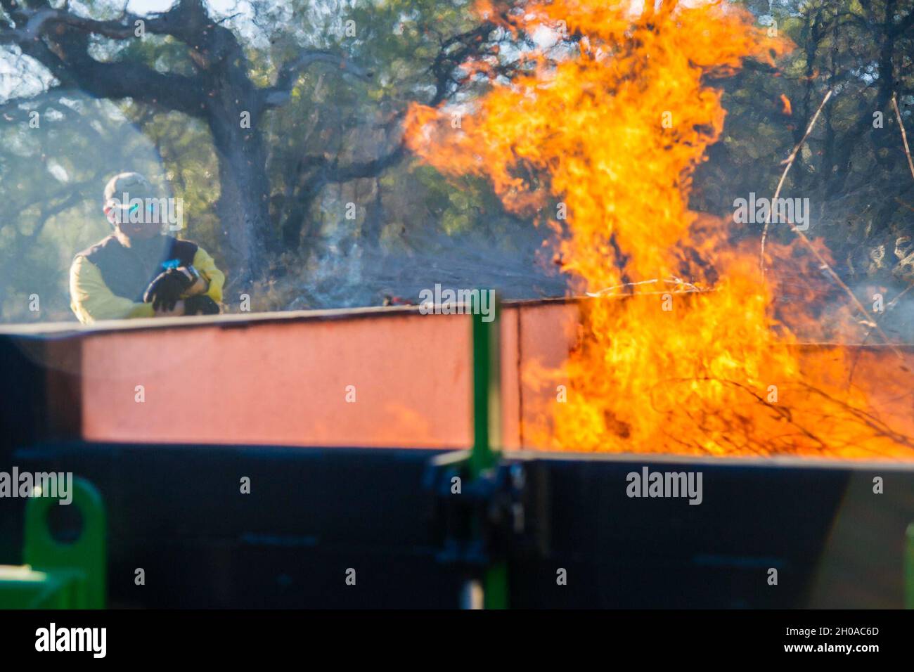 Gli equipaggi di lavoro sono composti da membri dell'802° Ingegnere civile Squadron, Joint base San Antonio Natural Resources Office, Texas A&M Natural Resources Institute e il modulo di supporto JBSA Wildland hanno bruciato pezzi di bambù dorato e pacciame di cedro in un inceneritore a cortina d'aria 7 gennaio 2021, presso JBSA-Camp Bullis, Texas. L'inceneritore è progettato per bruciare i detriti di sbarramento in cui le particelle di fumo vengono intrappolate e bruciate, riducendo le particelle di fumo a un limite accettabile consentito dalle linee guida dell'Agenzia per la protezione ambientale. Foto Stock
