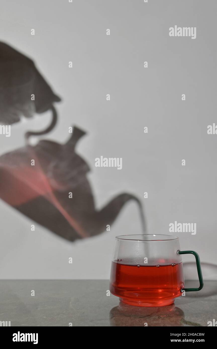 Estratto Pot e tazza di tè versando Foto Stock