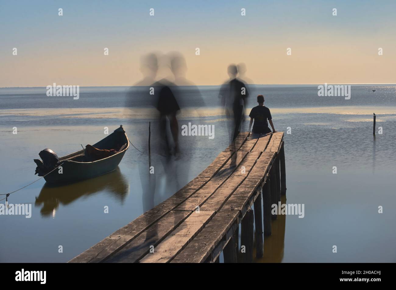 Astratto giovane uomo tempo che passa su Pontoon in legno Foto Stock