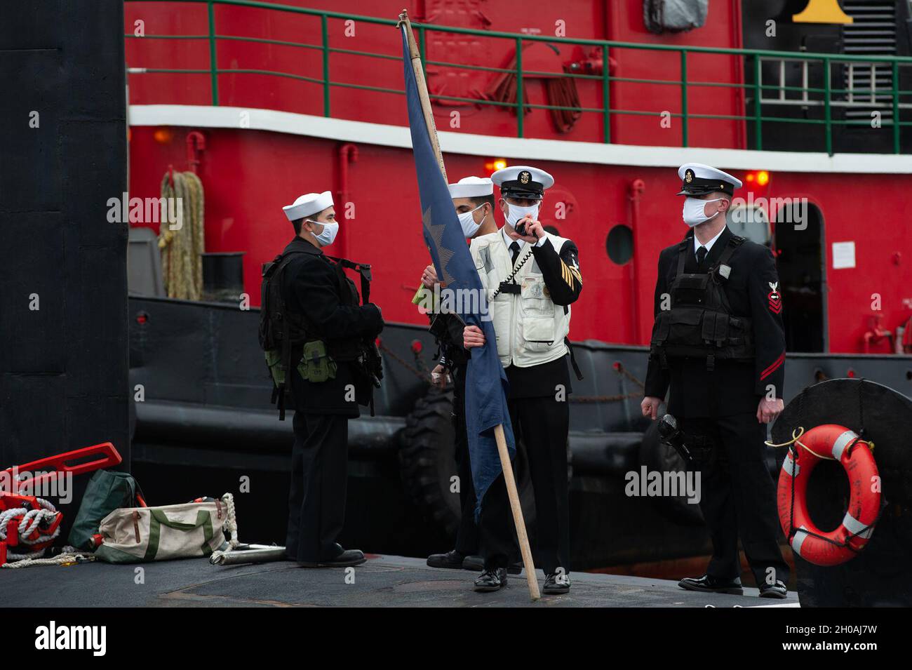 Il comandante Kellen Voland, capo del comando della USS North Dakota (SSN 784), detiene la bandiera dello stato del North Dakota mentre il North Dakota è tornato a casa alla base sottomarina di New London a Groton lunedì 11 gennaio 2021 a seguito di un dispiegamento regolare di sei mesi. Mentre era in dispiegamento, il North Dakota ha percorso 42,000 miglia nautiche per attuare la strategia marittima del capo dell’operazione navale nel sostenere gli interessi nazionali in materia di sicurezza e le operazioni di sicurezza marittima. Foto Stock