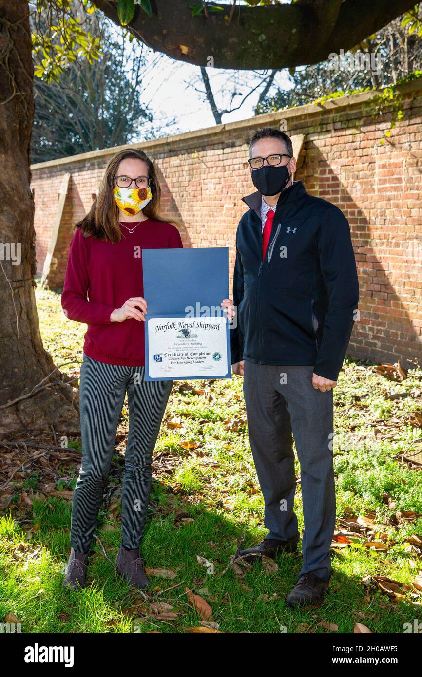 Dave Randall, Program Manager dei leader emergenti del cantiere navale di Norfolk, premia lo Specialista di gestione delle emergenze (Codice 1130) Alyx Riebeling con un certificato al completamento del programma di formazione informatica Leadership Development for Emerging Leaders. Foto Stock