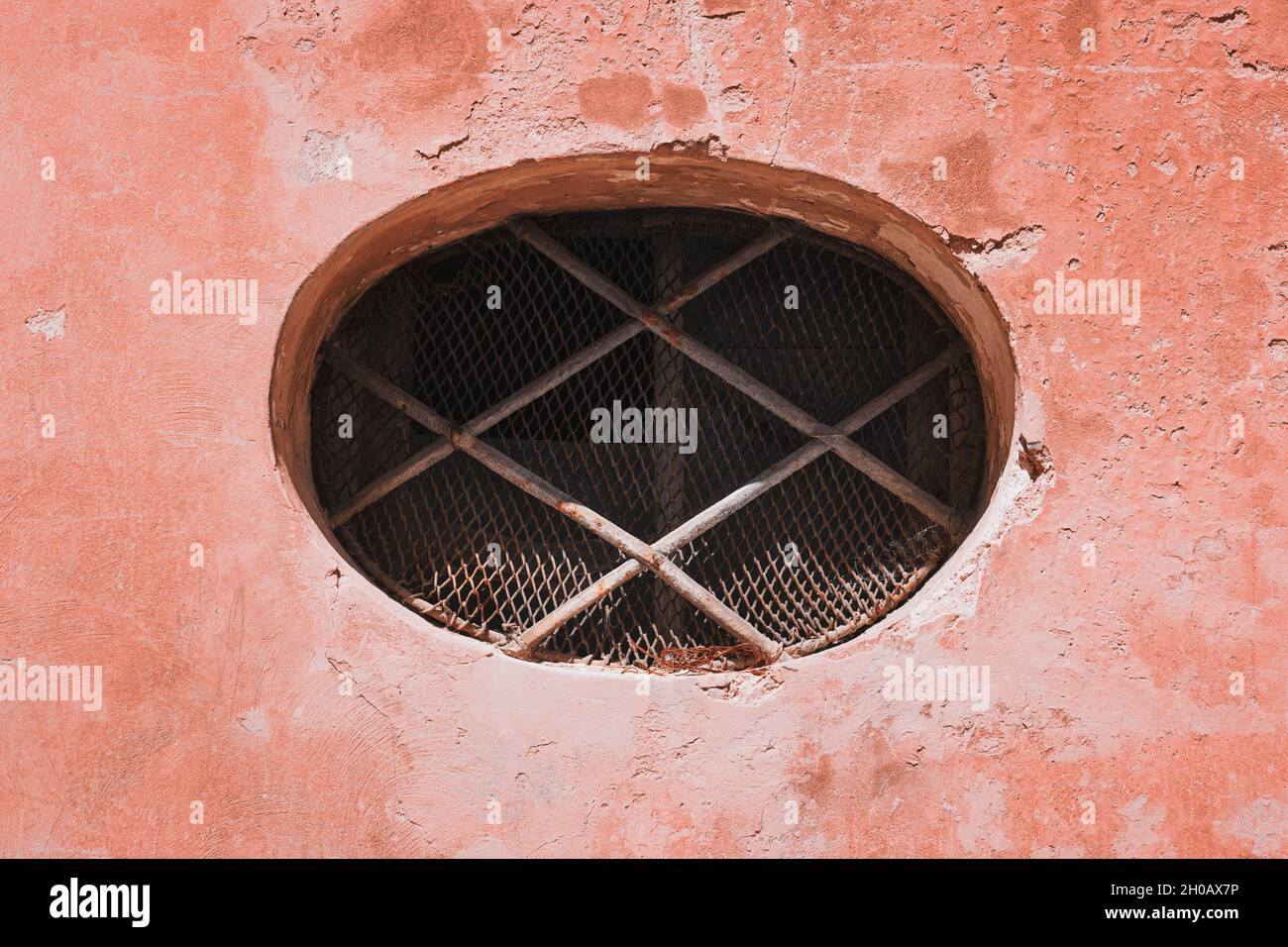 Finestra ovale con grate di vecchio edificio, esterno Foto Stock