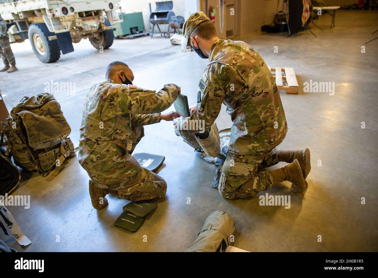 PFC. Kataurus Jones e PV2 Matthew Huie, entrambi i soldati della 114th Military Police Company, Mississippi Army National Guard, caricano le armature in un gilet portavie tattico nella loro Armory a Clinton, Miss., 14 gennaio 2021. Il 114th MP Co. Si sta preparando a dispiegarsi a Washington, D.C. come Capitol Response per la 59th Inaugurazione Presidenziale. Foto Stock