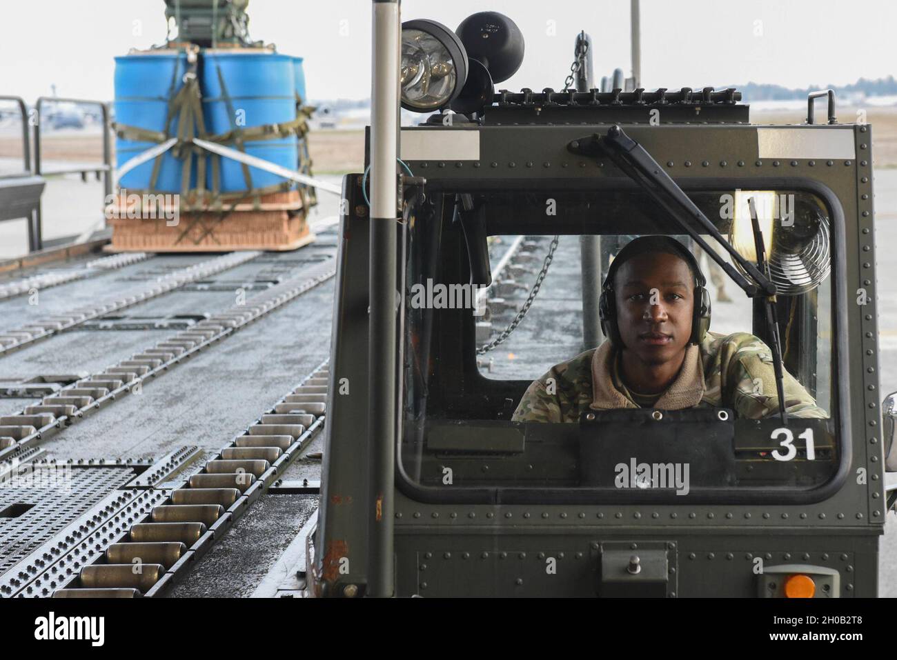 Senior Airman Terron Williams, 62nd Aerial Port Squadron Special Handling Representative, guida un K-Loader 60K “Tunner” alla Joint base Lewis-McChord, Washington, 14 gennaio 2021. Il 62o APS funge da porto principale per le spedizioni di passeggeri e merci nella regione nord-occidentale del Pacifico e supporta le missioni U.S. Transportation Command e /Air Mobility Command per i principali esercizi e implementazioni in tutto il mondo. Foto Stock