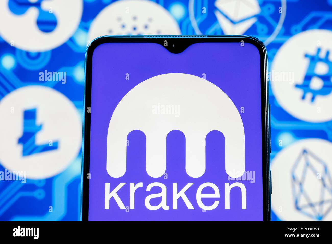 Kraken è uno scambio di criptovaluta. Logo Kraken sullo schermo dello smartphone sullo sfondo delle principali criptovalute. Foto Stock