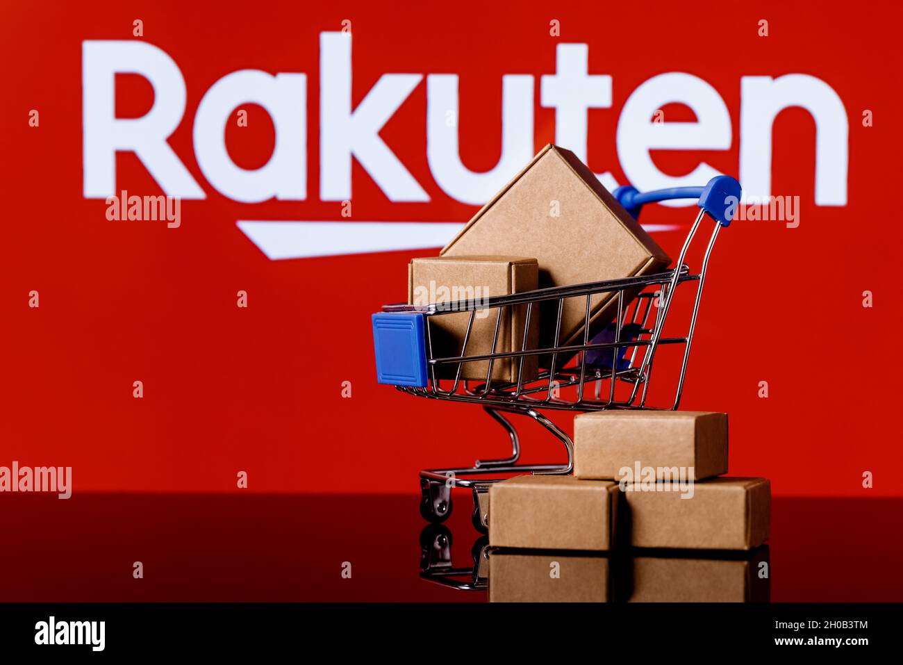 Rakuten Group è un'azienda giapponese di commercio elettronico e di vendita al dettaglio online. Carrello con pacchi sullo sfondo del logo Rakuten. Foto Stock