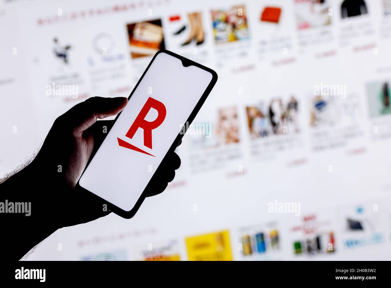 Rakuten Group è un'azienda giapponese di commercio elettronico e di vendita al dettaglio online. Uno smartphone con il logo Rakuten in una mano. Foto Stock