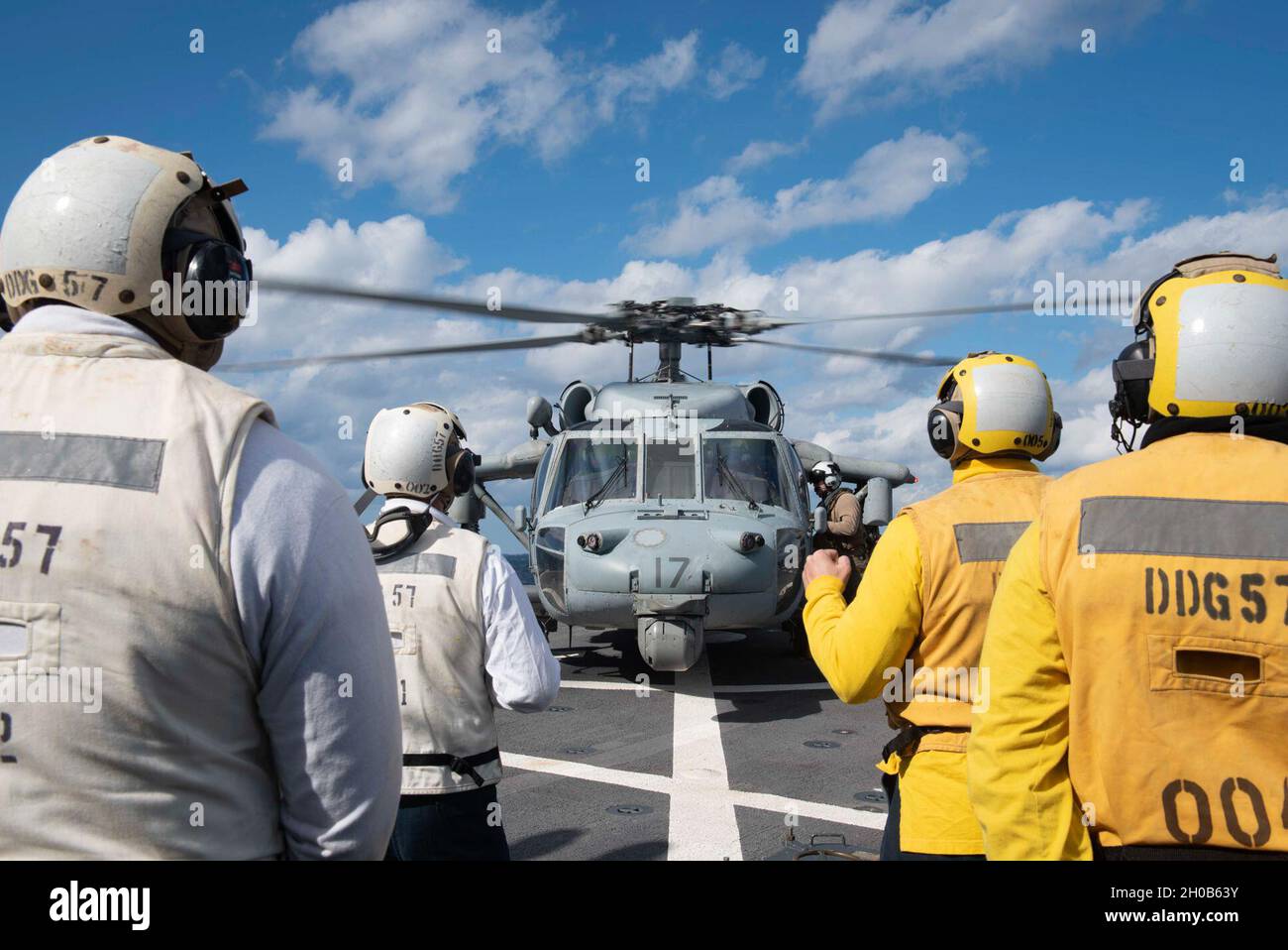 210115-N-QD512-1308 OCEANO ATLANTICO (GEN. 15, 2020) i marinai si levano in piedi durante il rifornimento di un falco marino MH-60, attaccato ai 'cani desti' di Squadron di combattimento del mare dell'elicottero (HSC) 7, sul ponte di volo a bordo del cacciatorpediniere-missile guidato di classe Arleigh-Burke USS Mitscher (DDG 57). Mitscher è attualmente in corso nell'Oceano Atlantico e svolge le proprie attività nell'ambito del Dwight D. Eisenhower Carrier Strike Group. Foto Stock