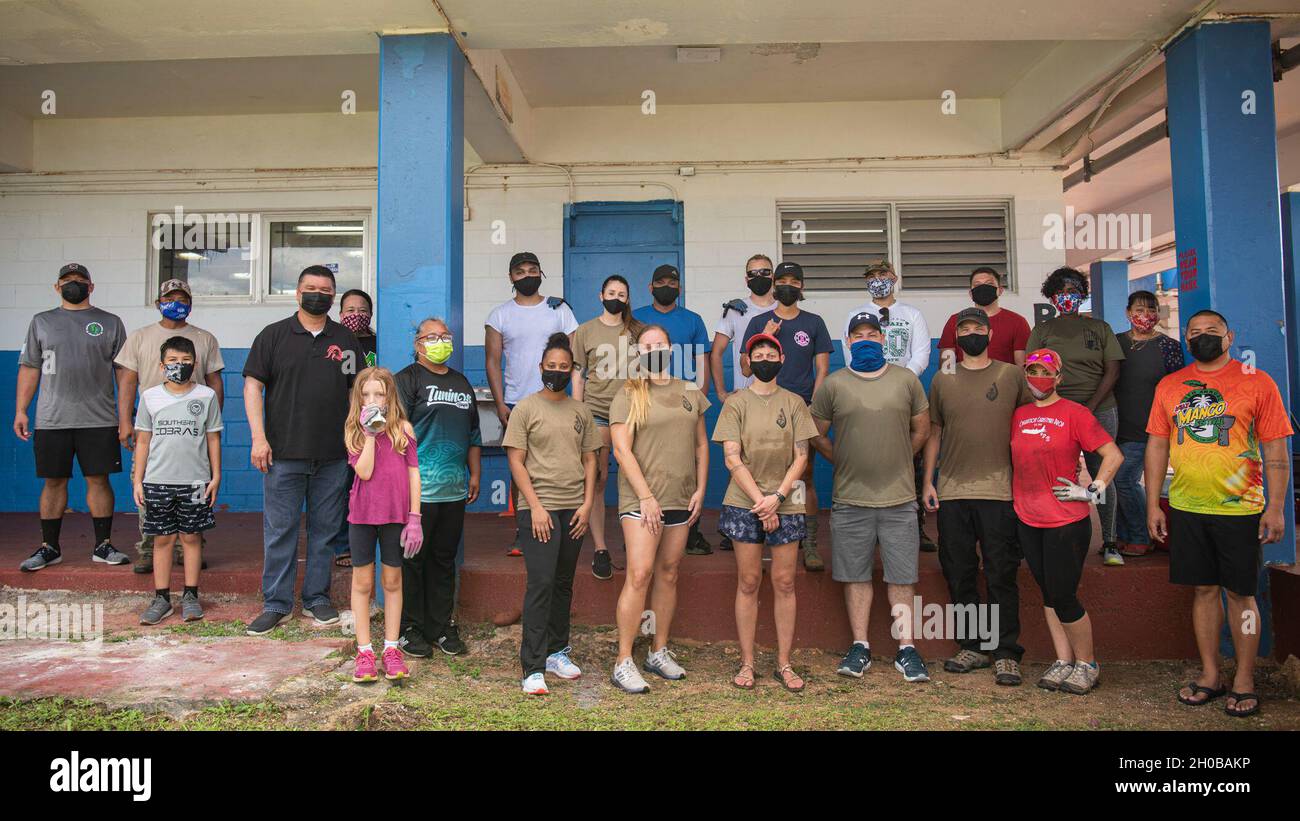 Gli airman del 36esimo Squadrone delle operazioni sanitarie; Kevin Susuico, sindaco di Agat, estrema destra; e il personale della scuola media Oceanview scattano una foto di gruppo dopo un evento di bellezza alla scuola media Oceanview di Agat, Guam, 16 gennaio 2020. Quindici membri dello squadrone hanno trascorso quattro ore a rimuovere i detriti e i rifiuti insieme al personale della scuola e dell'ufficio di Agat Mayor, preparando il campus agli studenti per il ritorno. Foto Stock