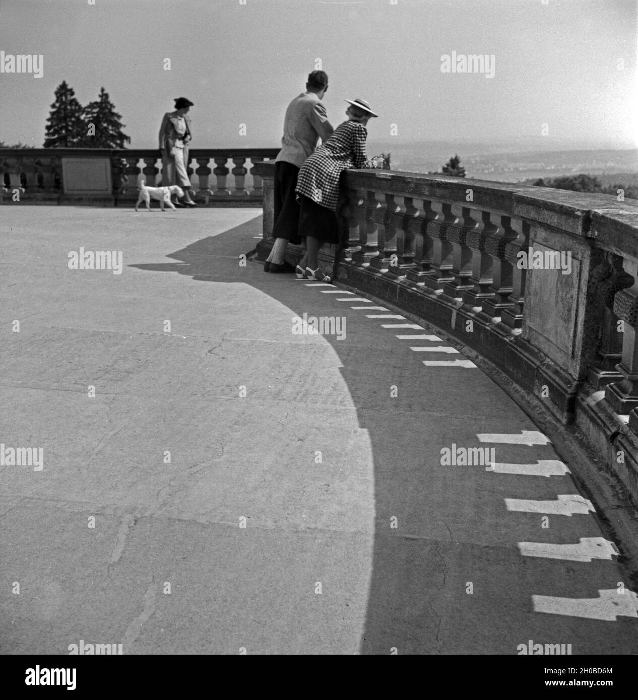 Ein Mann und zwei Frauen genießen die Aussicht vom Balkon von Schloß solitudine di Stoccarda, Deutschland 1930er Jahre. Due donne e un uomo godendo la vista dal balcone al castello Solitude a Stoccarda, Germania 1930- Foto Stock