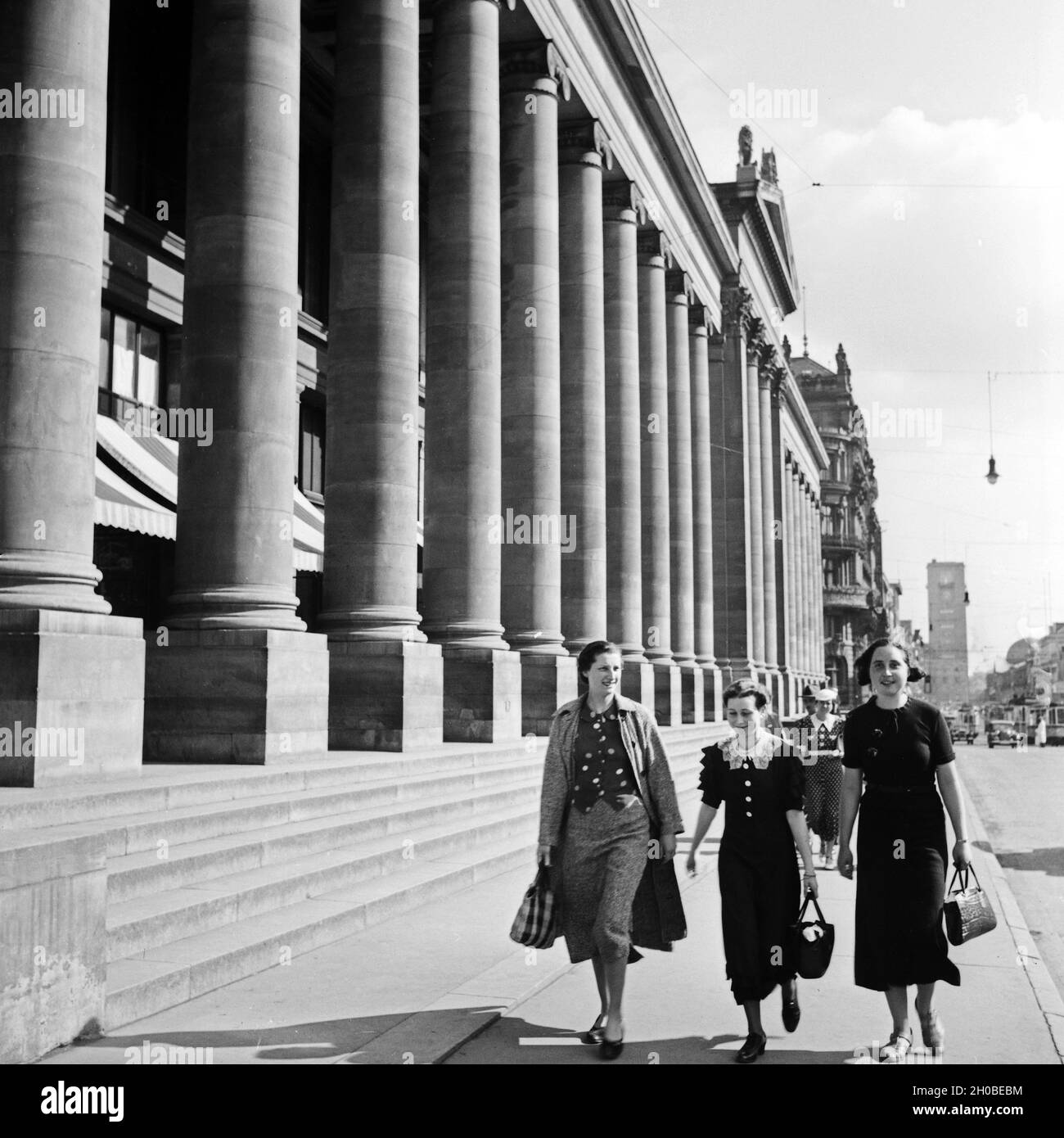 Drei Frauen kommen vom Einkauf am Königsbau a Stoccarda vorbei, Deutschland 1930er Jahre. Tre donne provenienti dai negozi lungo il palazzo Koenigsbau a Stoccarda, Germania 1930s. Foto Stock