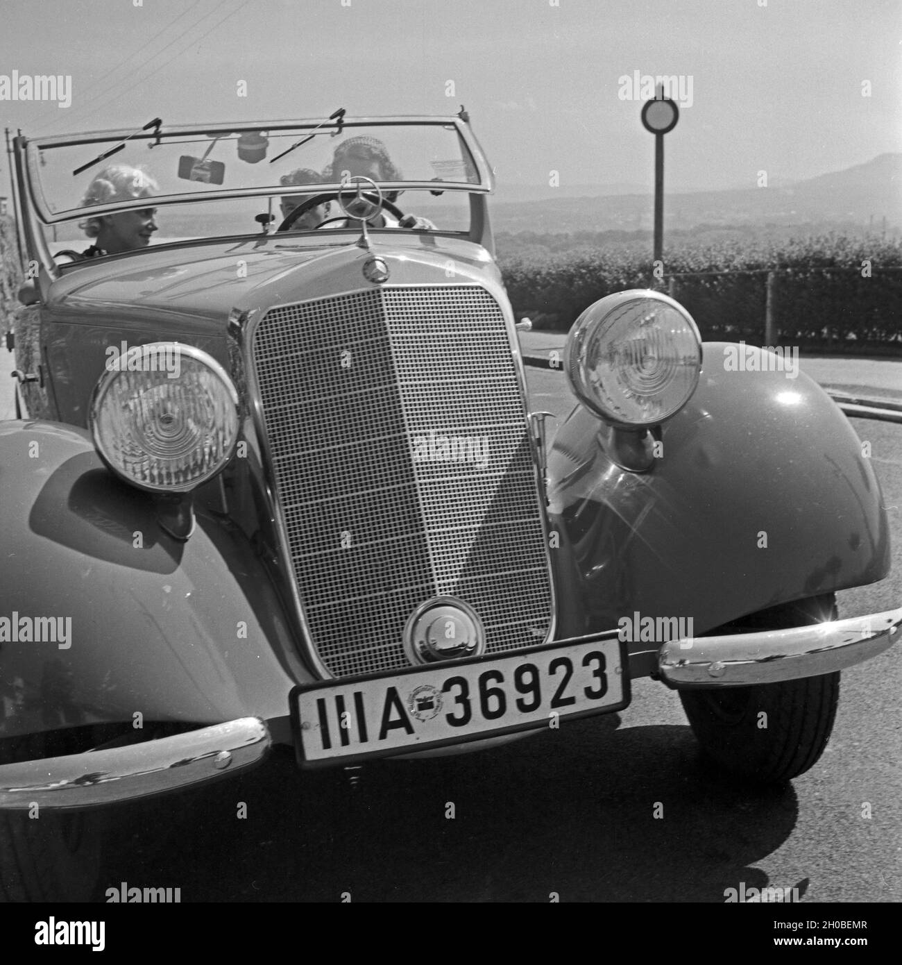 Zwei Frauen und ein Mann unterwegs in einem Mercedes Benz Cabrio, Deutschland 1930er Jahre. Due donne e un uomo sul loro modo in una Mercedes Benz cabrio, Germania 1930s. Foto Stock