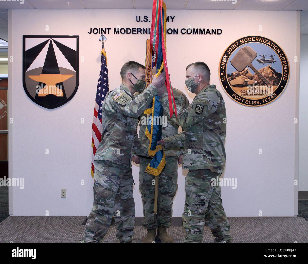 Comando Sgt. Christopher Gunn (a destra) passa i colori JMC al col. Tobin Magsig durante la cerimonia di rinuncia della responsabilità di Gunn il 19 gennaio a Fort Bliss, Texas. Foto Stock