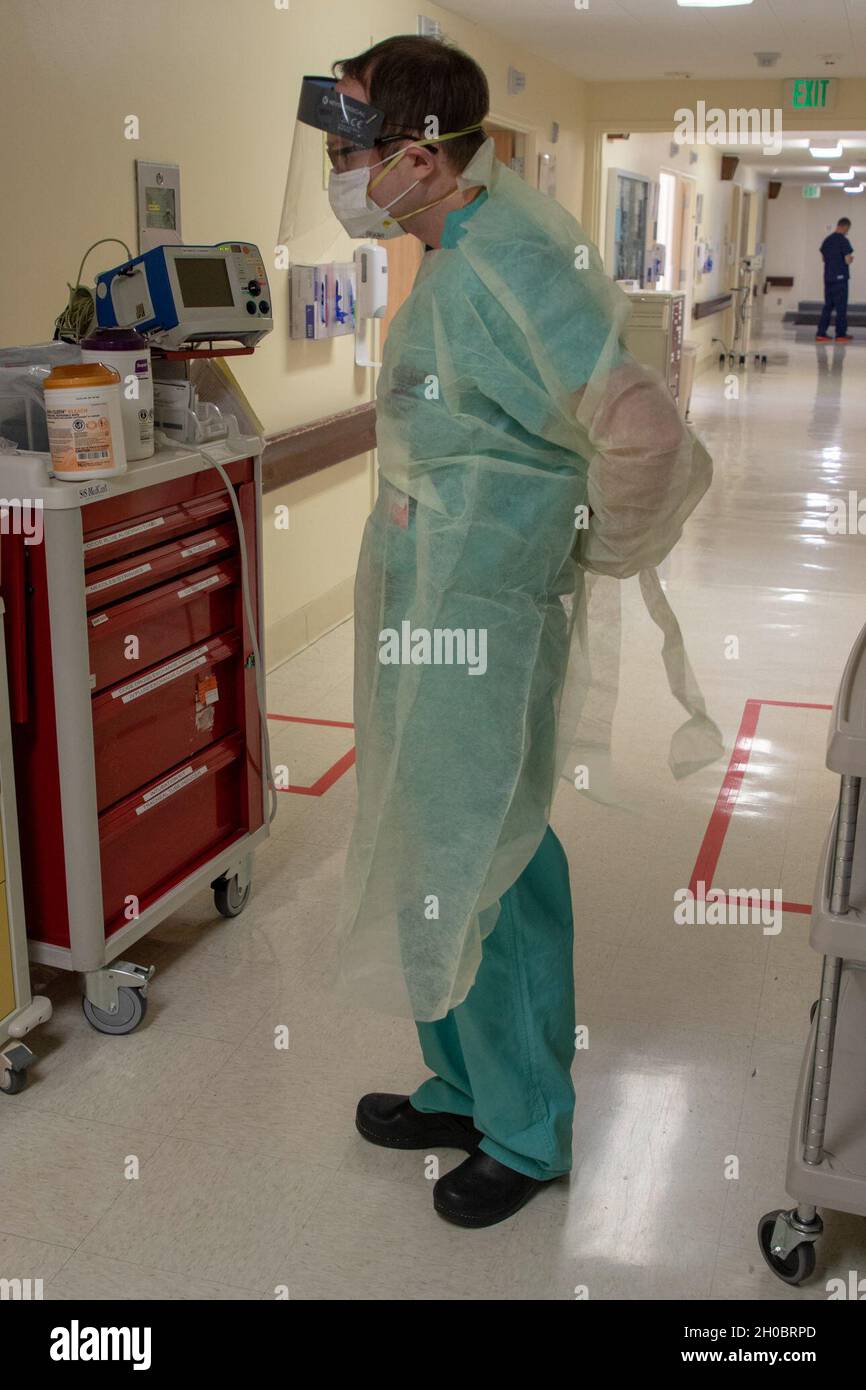 Tim Dempsey, un medico polmonare e di terapia critica assegnato al 60° Air Mobility Command, Travis Air Force base, California, mette sul suo equipaggiamento protettivo personale prima di trattare un paziente all'ospedale Adventist Health Lodi Memorial Hospital, Lodi, California, 20 gennaio 2021. Il comando del Nord degli Stati Uniti, attraverso Army North, rimane impegnato a fornire un supporto flessibile del Dipartimento della Difesa alla risposta COVID-19 dell'intero governo. Foto Stock