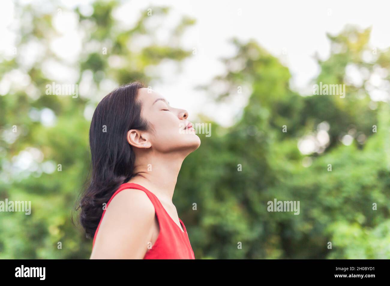 Ritratto di bella donna sensazione viva respirando aria fresca con occhi chiusi. Foto Stock