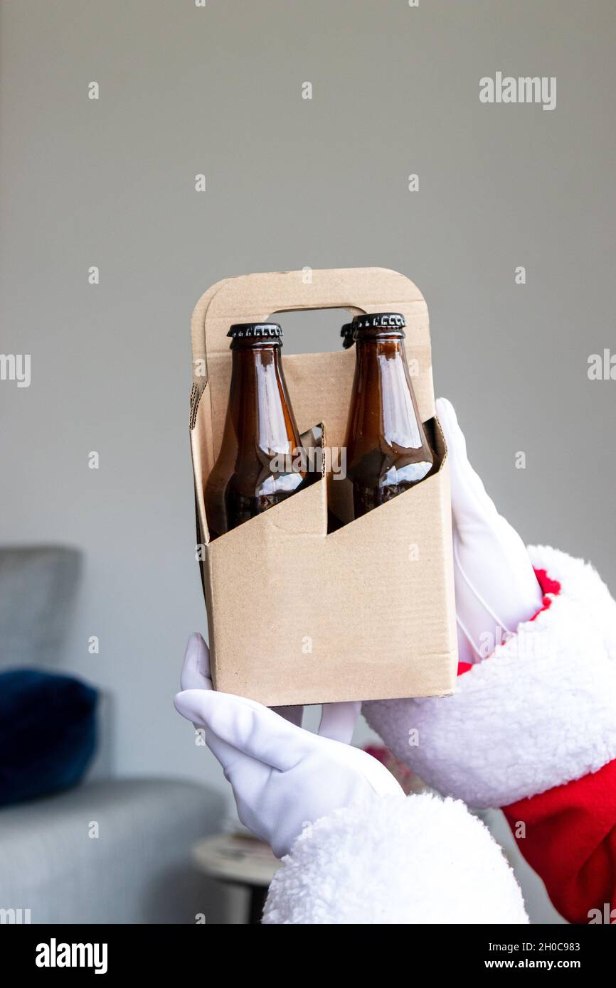 Babbo Natale che mostra un pacchetto di 4 birre artigianali con le mani Foto Stock Babbo Natale che mostra un pacchetto di 4 birre artigianali con le mani Foto Stock