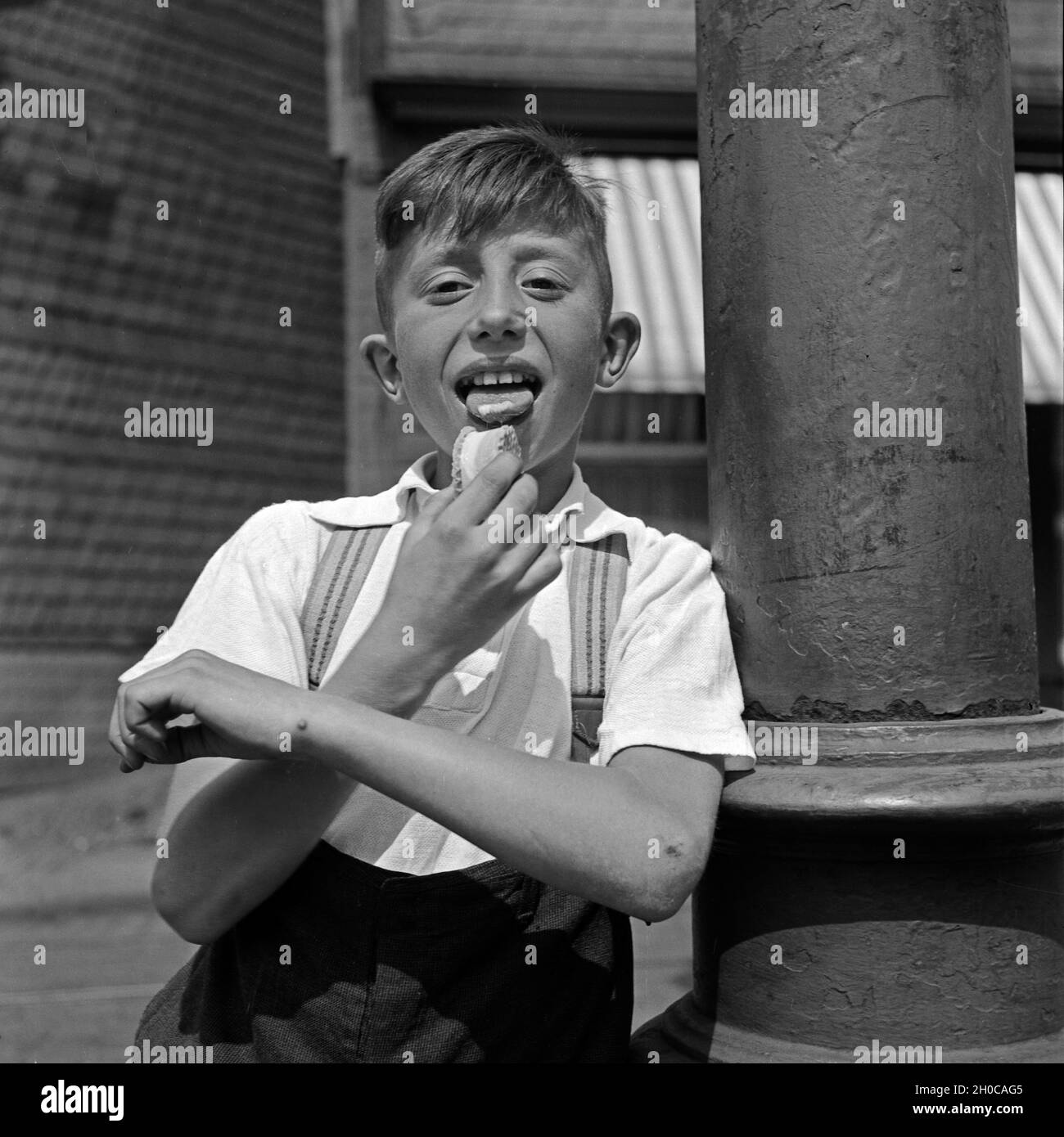 Ein Junge leckt seine Eiswaffel Deutschland 1930er Jahre. Un ragazzo leccare i gelati wafer, Germania 1930s. Foto Stock