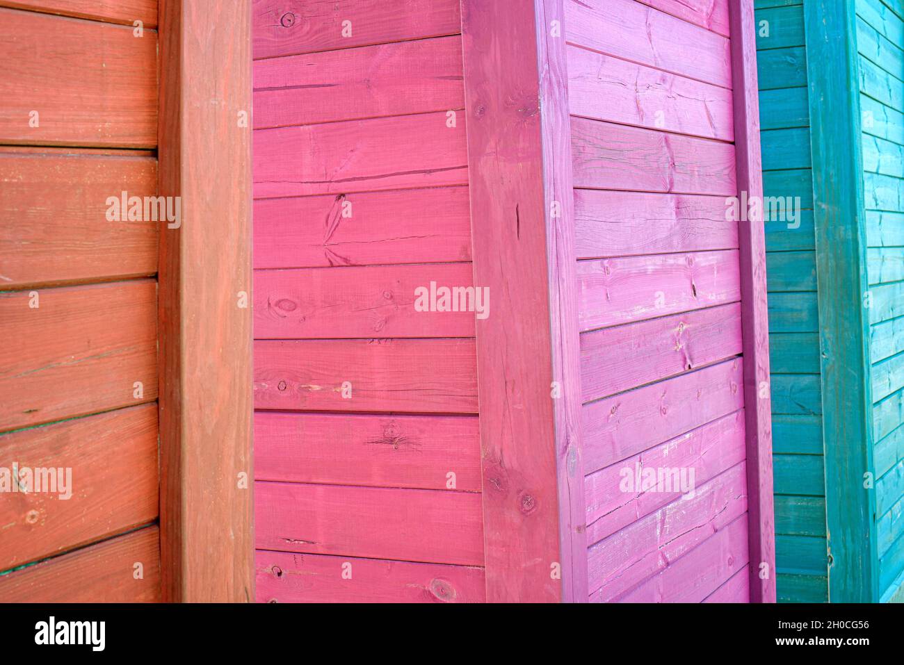Tre capannoni di legno colorati. Sfondo colorato con texture in legno. Foto Stock
