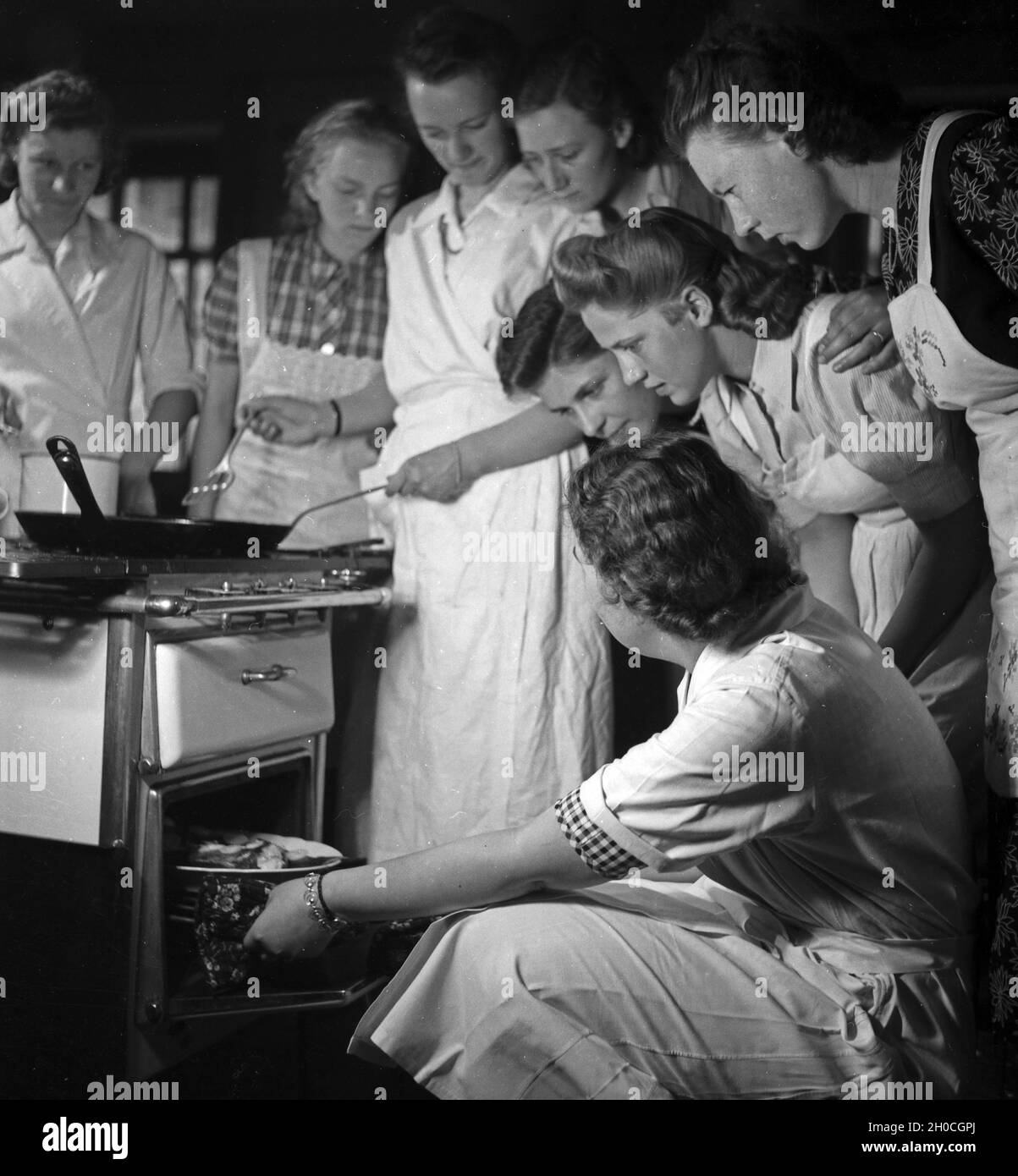 Frauen üben sich in der Hauswirtschaft in einer der BDM Arbeitsgemeinschaften 'Kochen', Deutschland 1930 Jahre. Donne che esercitano e praticano l'economia nazionale in uno dei laboratori BDM 'Kochen' ('Cooking'); Germania anni trenta. Foto Stock
