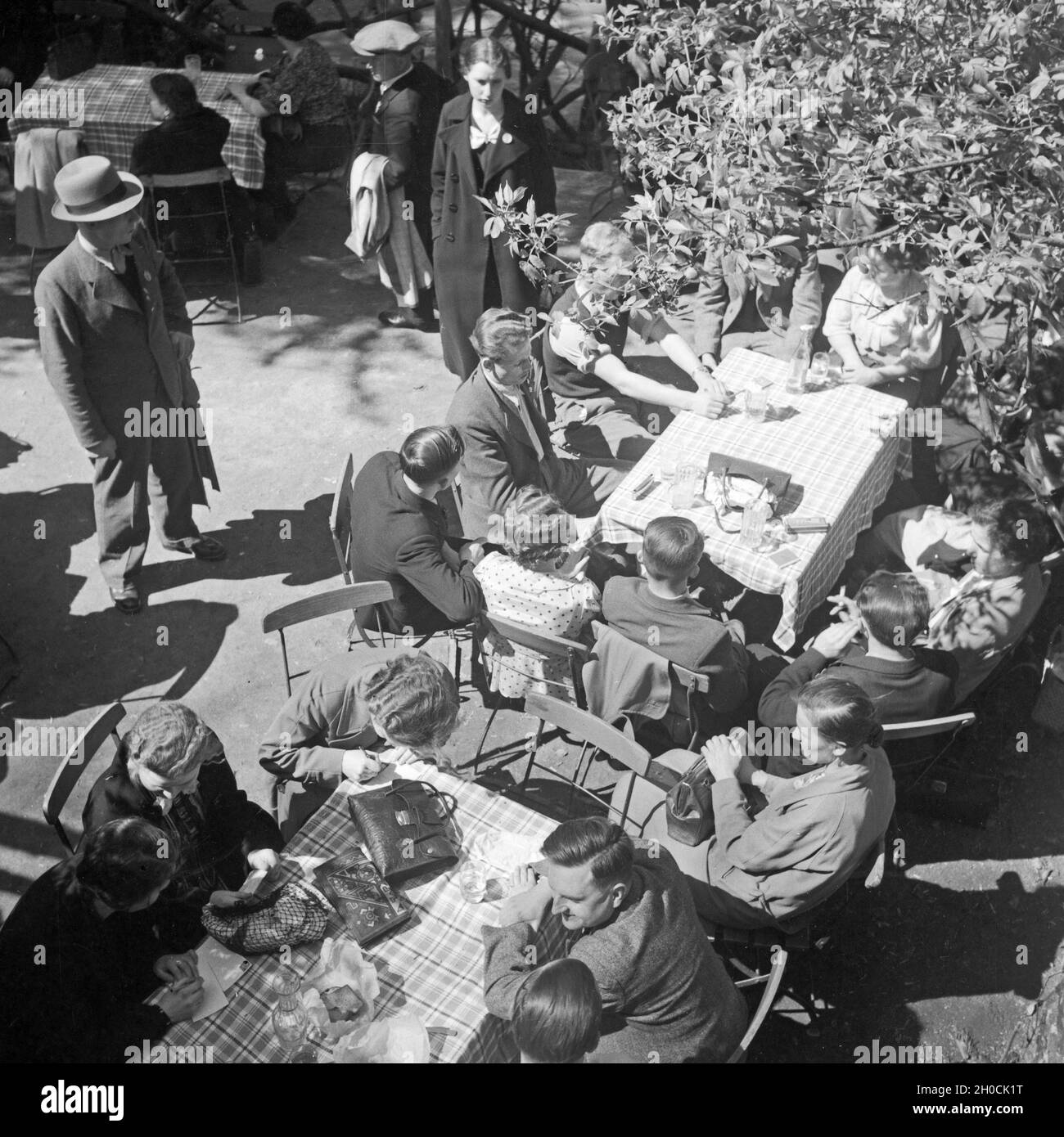 Menschen sitzen in einem Gartenrestaurant (ristorante nel giardino), Deutschland 1930er Jahre. La gente seduta in un ristorante con giardino, Germania 1930s. Foto Stock