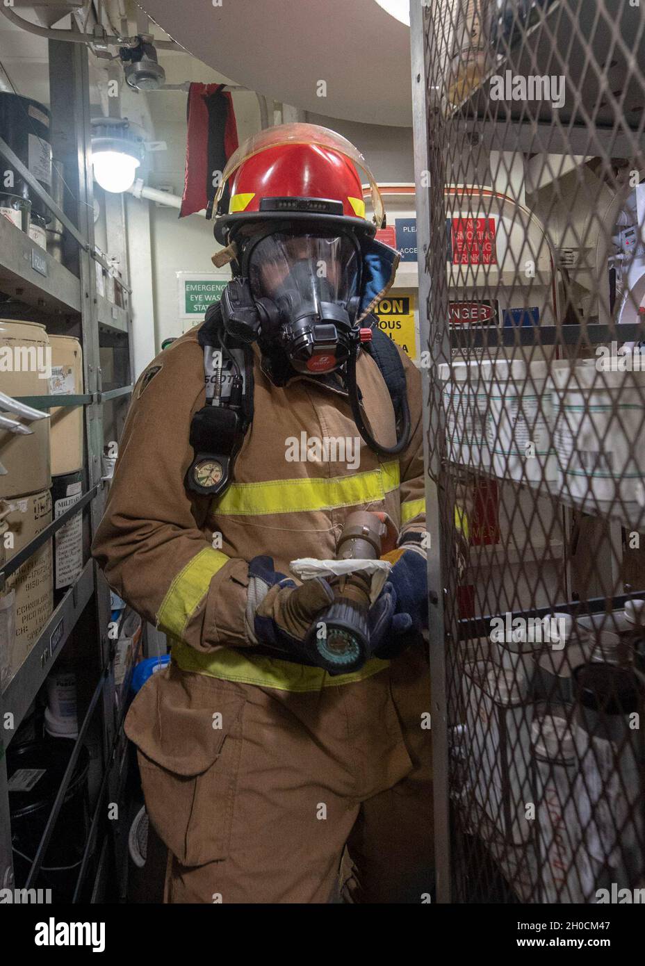 OCEANO PACIFICO (Gen. 23, 2021) U.S. Navy Information Systems Technician 3rd Class Nicholas Richard, di Biloxi, Missis., combatte un incendio simulato durante un'esercitazione di controllo dei danni a bordo dell'incrociatore missilistico guidato di classe Ticonderoga USS Bunker Hill (CG 52) 23 gennaio 2021. Bunker Hill, parte del Theodore Roosevelt Carrier Strike Group, è in fase di dispiegamento programmato per l'area operativa della 7a flotta statunitense. Essendo la più grande flotta della Marina militare statunitense, con le sue circa 50-70 navi e sottomarini, 140 aerei e 20,000 marinai nell'area operativa in un determinato momento, la 7a flotta conduce fo Foto Stock