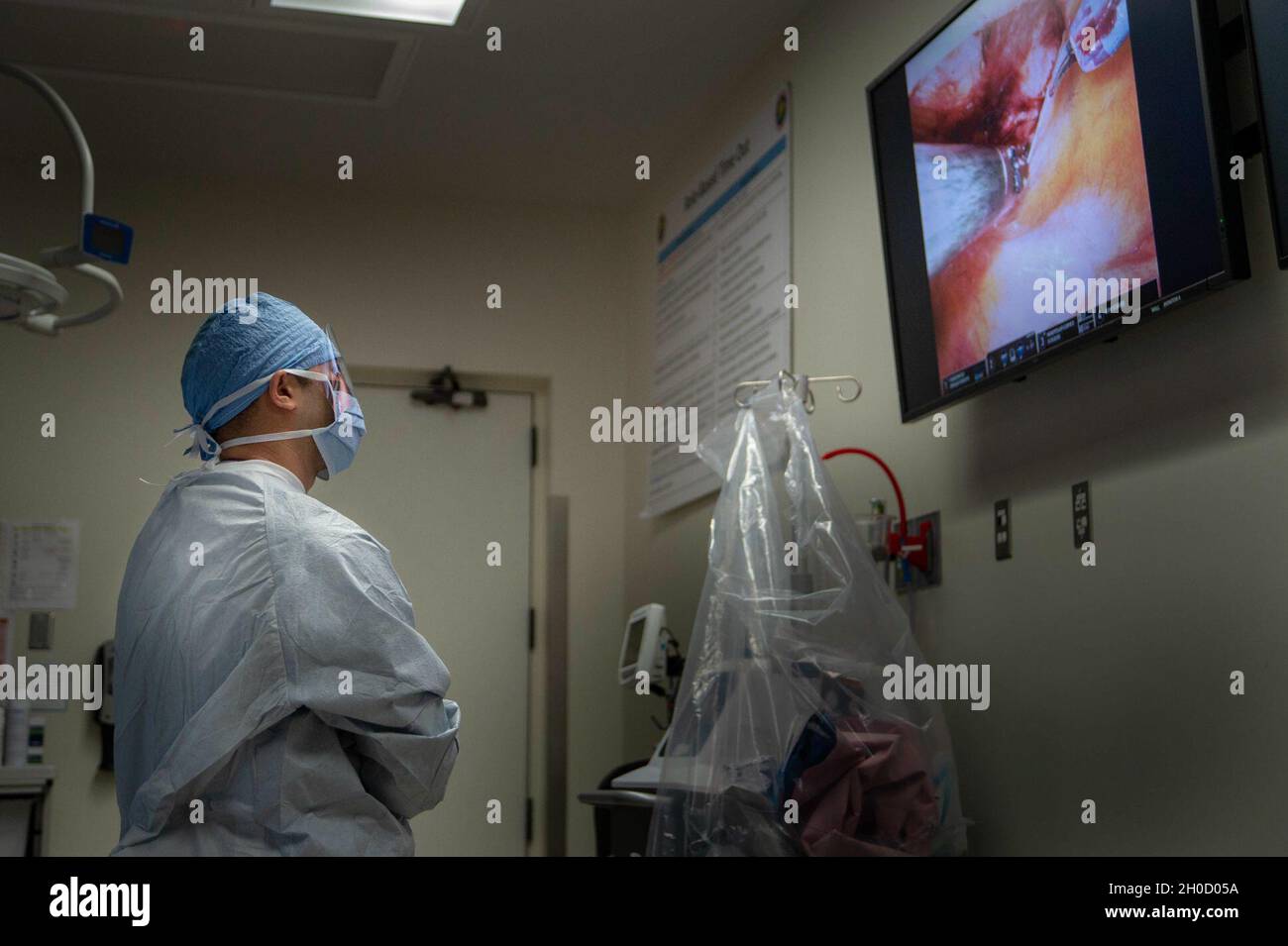 210127-N-LW757-1057 SAN DIEGO (GEN. 27, 2020) Ens. Trung ho, un'università di servizi uniformi dello studente di Scienze della Salute, osserva una procedura di riparazione dell'ernia inguinale laparoscopica assistita da robot in una delle sale operatoria dell'ospedale di gennaio 27. I sistemi chirurgici robotici, come quelli utilizzati presso NMCSD, consentono ai chirurghi di eseguire procedure minimamente invasive, e questa procedura è stata eseguita durante uno studio remoto di tele-mentoring. La missione di NMCSD è preparare i membri del servizio a schierarsi a sostegno delle forze operative, fornire servizi sanitari di alta qualità e plasmare il futuro della medicina militare Foto Stock