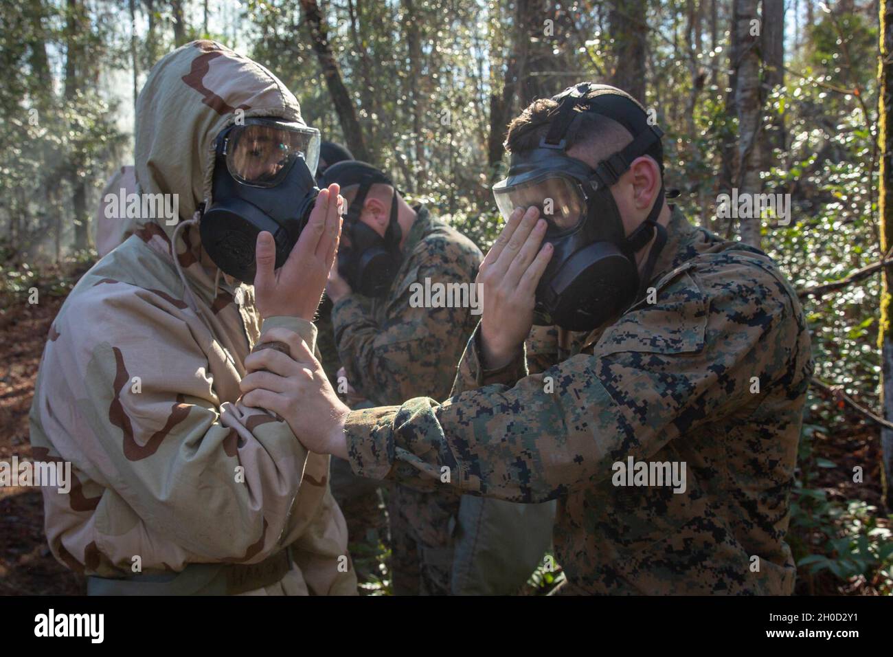 US Marine Corps PFC. John Thies (a destra), un missileman anti-serbatoio con 2d Light Armored Reconnaissance Battaglione, 2d Marine Division, dà il via libera alla sua M50 Joint Service General Purpose Masks durante un esercizio individuale di fiducia sui dispositivi di protezione su Camp Lejeune, N.C., 28 gennaio 2021. I Marines hanno provato a indossare e ripulire le loro maschere per uso generale M50 Joint Service in un ambiente contaminato, e hanno ricevuto istruzioni su come reagire dopo un attacco di CBRN nozionale nel campo. Foto Stock