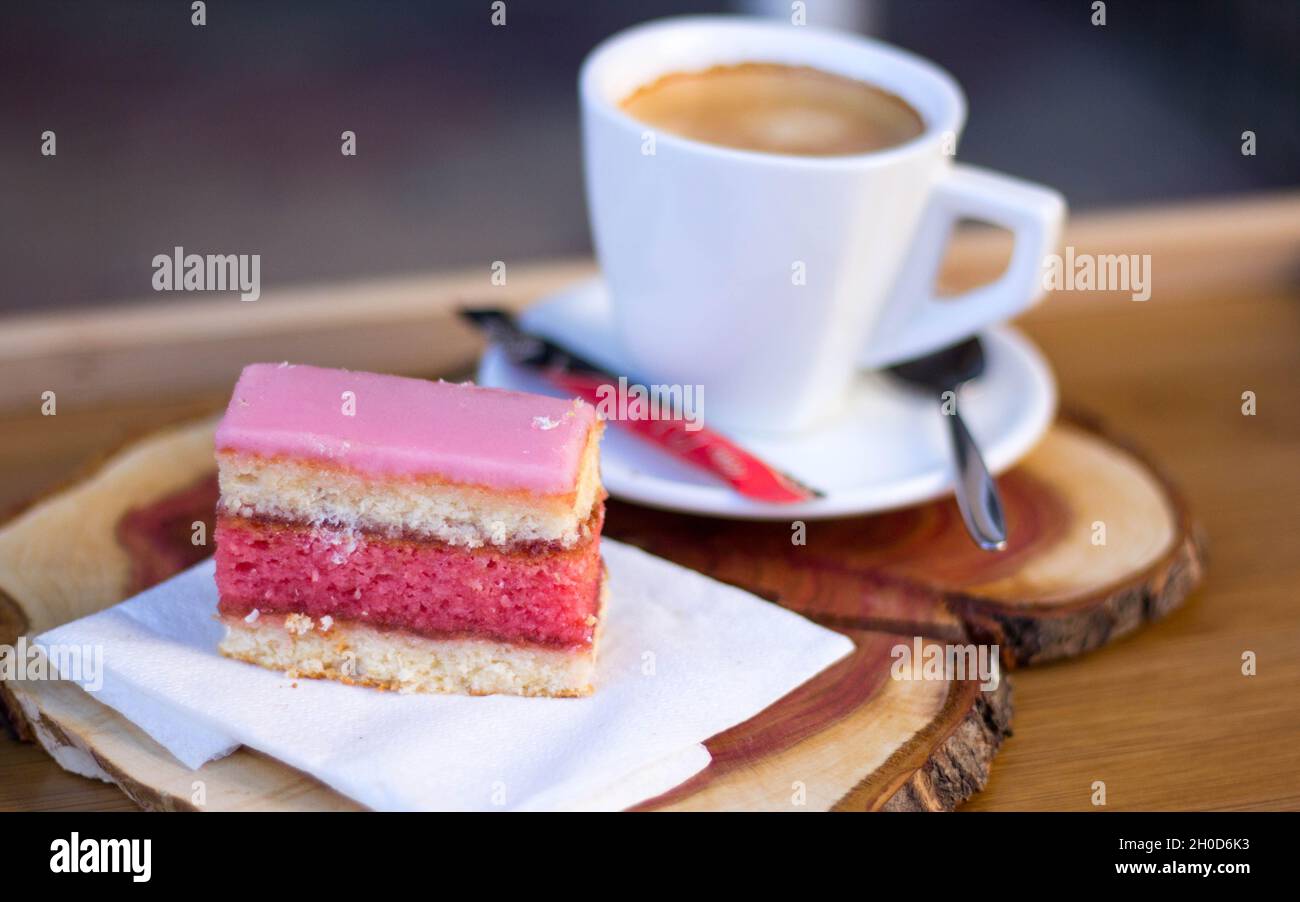 Fetta di Punch (Rum Tea) torta con caffè su tavola di legno Foto Stock