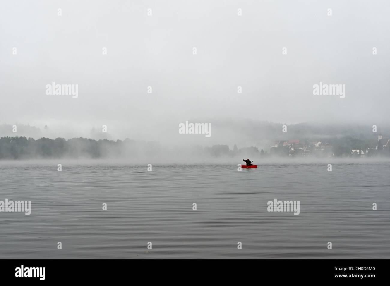 Pescatore in barca la mattina presto sul lago Lipno nelle montagne Sumava, Repubblica Ceca Foto Stock