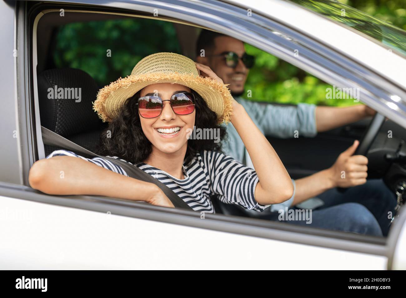 Sorridenti amanti del centro-est andare in spiaggia in auto Foto Stock