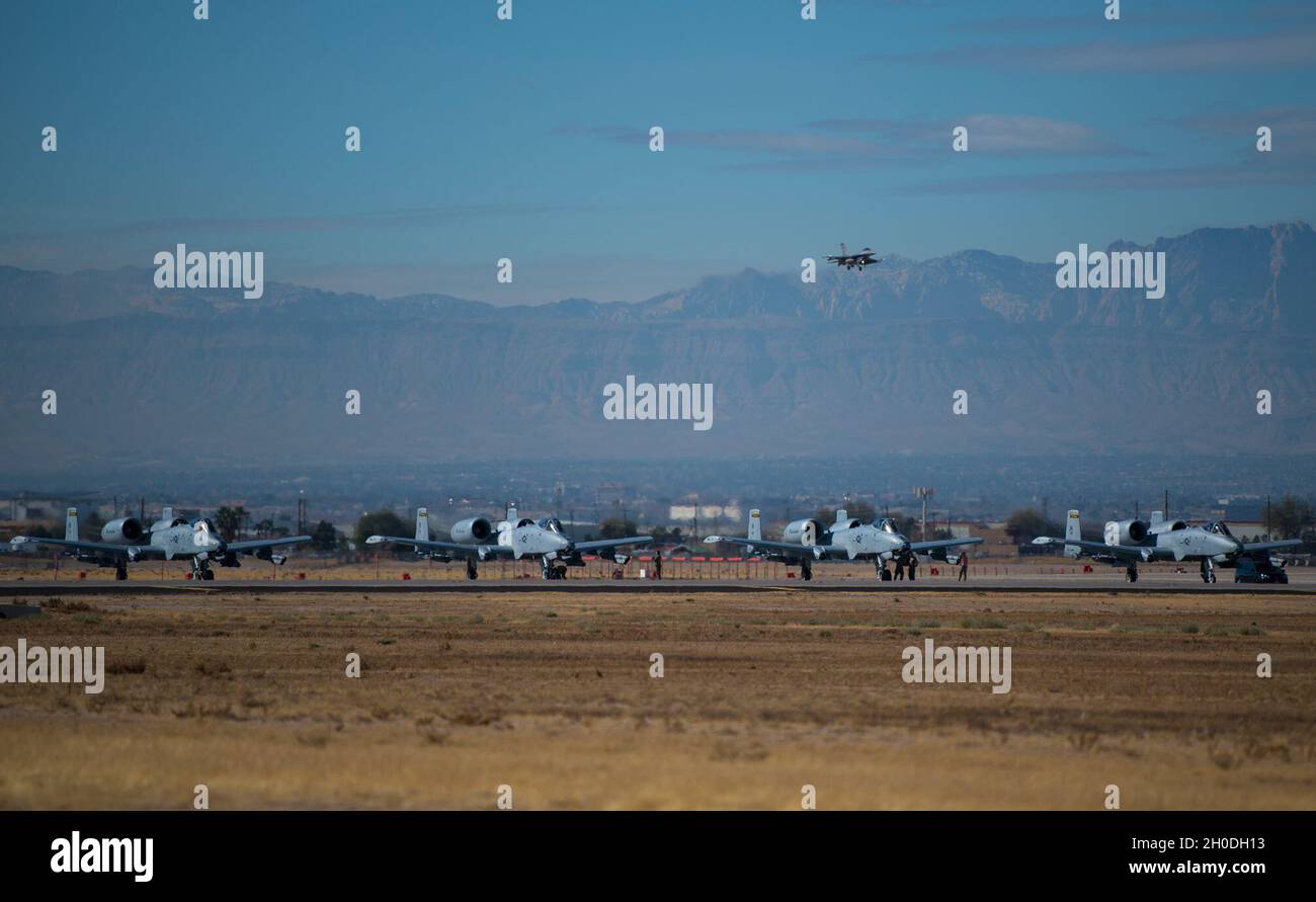 Un pilota di F-16 Fighting Falcon taxi passa un A-10C Thunderbolt II aereo assegnato alla 122nd Fighter Wing, Indiana Air National Guard, durante la bandiera rossa 21-1 alla base dell'aeronautica di Nellis, Nevada, 2 febbraio 2021. La manifestazione comprende una serie di aerei in aggiunta alla A-10C Thunderbolt II, tra cui F-22 Raptor, F-35 Lightning II, F-16 Fighting Falcon, EA-18G Growler, F-15E Strike Eagle, B-1B Lancer e lo Spirito B-2. Foto Stock