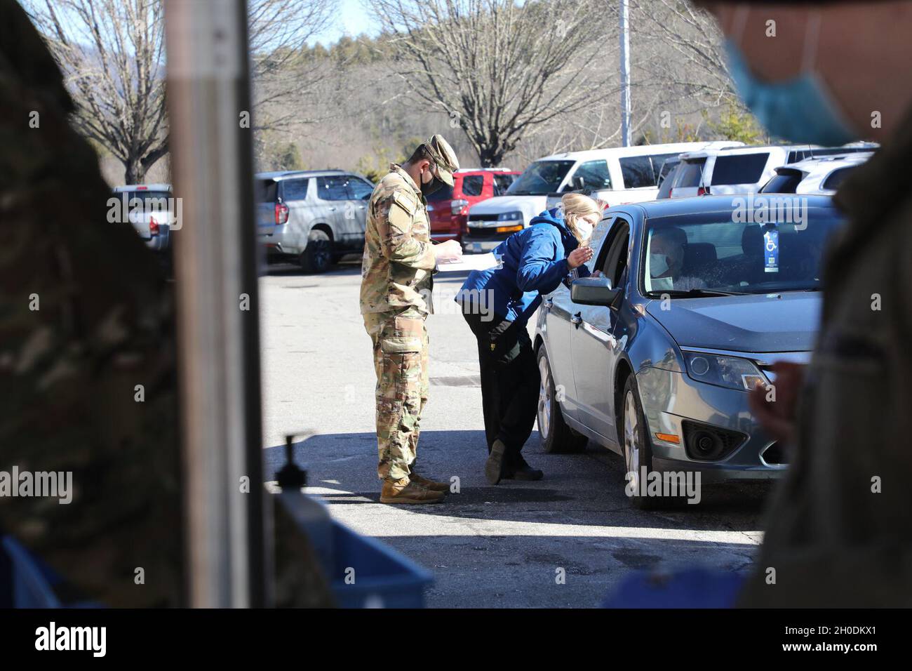 SGT. Kyle Cramer, un ingegnere di combattimento assegnato al 236a brigata ingegnere Battaglione, 30th Armored Brigade Combat Team, e Ruthie Capaforte, un infermiere per il dipartimento di sanità pubblica della contea di Macon, valuta un paziente prima di ricevere la sua vaccinazione COVID-19 a Franklin, Carolina del Nord, 9 febbraio 2021. I soldati della Guardia Nazionale del North Carolina e gli Airmen sono attivati in tutto lo stato per assistere i dipartimenti sanitari locali con l'aumento dell'efficienza della somministrazione dei vaccini. Foto Stock