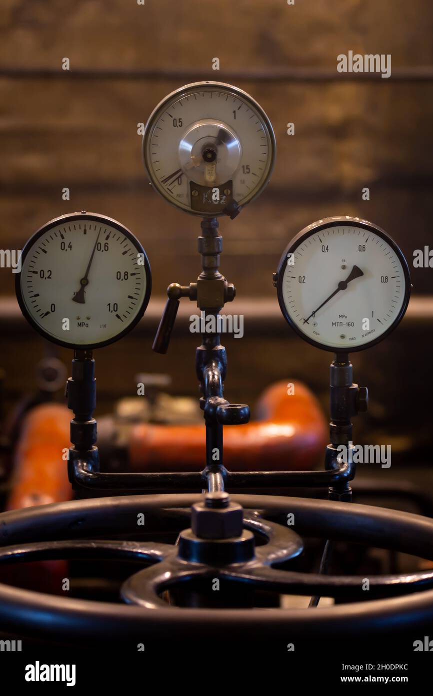 Vecchi manometri analogici su un impianto a vapore industriale. Foto scattate in condizioni di scarsa illuminazione, luce naturale Foto Stock