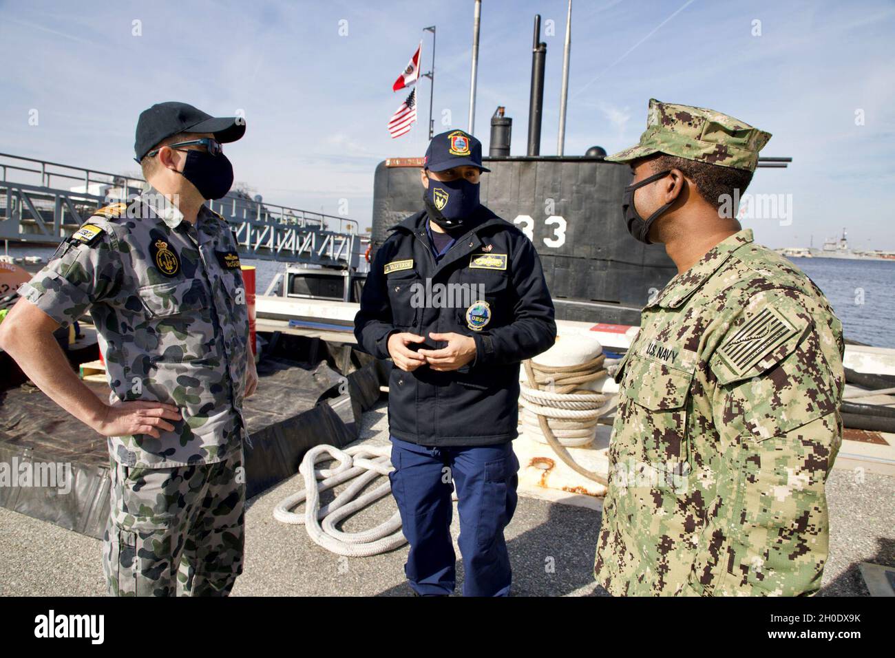 Il Lt. Matthew McGuire (RAN) e il Lt. Reginald Caldwell parlano con un ufficiale del sottomarino peruviano BAP Pisagua (SS-33) alla Stazione Navale Mayport. Pisagua partecipa a esercitazioni e formazione nell'ambito dell'iniziativa per il sottomarino diesel-elettrico, che si svolge nel ventesimo anno. Foto Stock