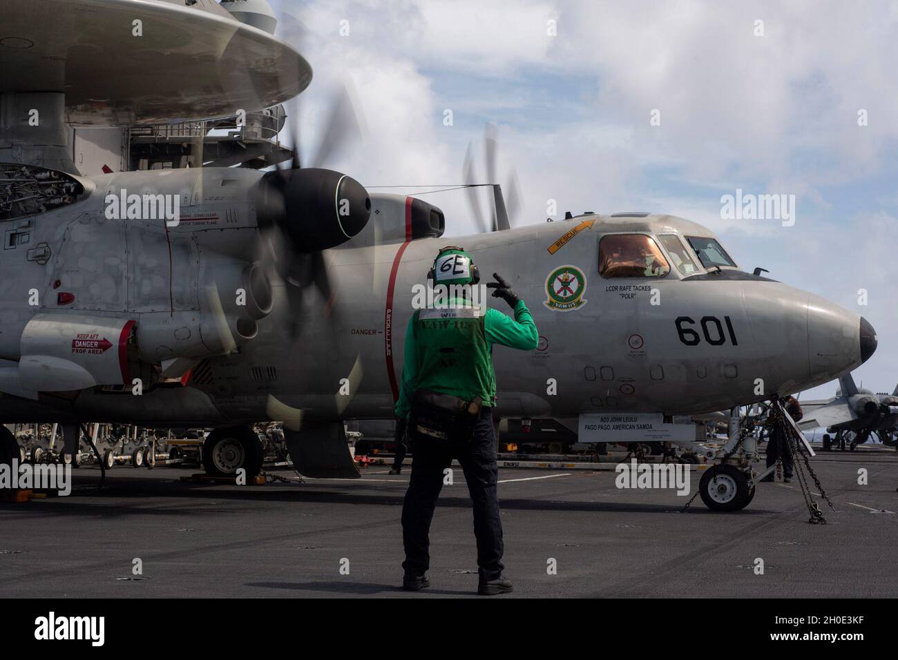 OCEANO PACIFICO (Feb 6, 2021) – il compagno di classe Hoang Huynh della U.S. Navy Aviation Electrician’s Mate 2nd Class, di Norwood, Pa., fa parte di una catena di sicurezza per un e-2C Hawkeye, assegnato ai “Liberty Bells” della Airborne Command and Control Squadron (VAW) 115, Durante una bassa potenza accendere il ponte di volo della portaerei USS Theodore Roosevelt (CVN 71) 6 febbraio 2021. Il gruppo Theodore Roosevelt Carrier Strike è in fase di dispiegamento programmato per l'area operativa della 7a flotta statunitense. Come la flotta più grande della Marina degli Stati Uniti schierata in avanti, con i suoi circa 50-70 navi e sottomarini, 140 aerei e 20,00 Foto Stock