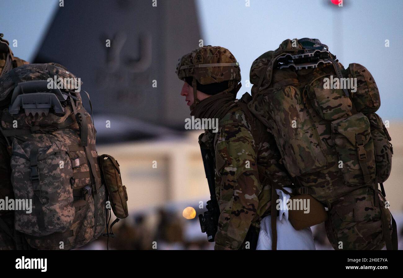 I paracadutisti dell'esercito degli Stati Uniti, assegnati alla quarta squadra di combattimento di Brigata di fanteria (Airborne), 25 divisione di fanteria (Spartan Brigade), si preparano a salire a bordo di un C-130J Super Hercules, assegnato alla 36a squadra di Airlift, Yokota Air base, Giappone, durante l'esercitazione Arctic Warrior 21 alla Joint base Elmendorf-Richardson, AK, 8 febbraio 2021. Durante l'esercizio, diversi equipaggi di base e aerei dell'esercito statunitense e dell'aviazione militare e partner canadesi hanno lavorato insieme per eseguire l'operazione in condizioni invernali artiche remote ed estreme, e infine garantire che tutte le forze coinvolte continuino a lavorare in modo coeso per superare il problema Foto Stock