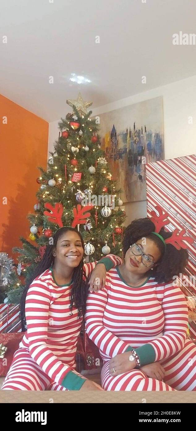 WIESBADEN, Germania – (da destra a sinistra) il Dr. Sturhonda James, specialista della sicurezza informatica del Dipartimento della Difesa, e il suo fidanzato, Shakima Bates, posano in pajamas corrispondenti per il loro Natale saluto 2020 dicembre. Foto Stock