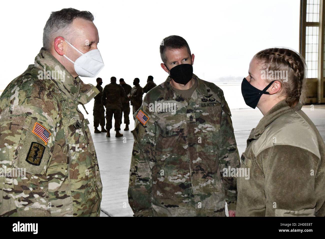 SPC. Angela Thresher (centro), una medica di combattimento 68W dallo Stato di Washington, che è stato identificato come il 10.000° soldato a partire da MEDCoE in modo controllato come parte della pandemia COVID-19, parla con il Gen. Dennis LeMaster, il comandante generale di MEDCoE e il comando Sgt. Major Clark Charpentier, MEDCoE comando Sergente maggiore. U.S. Army Medical Center of Excellence il 11 febbraio 2021 come hanno condotto un movimento controllato in uscita dalla Joint base di San Antonio (JBSA)- Kelly Field per oltre 250 soldati in partenza Advanced Individual Training (AIT) in vari settori militari medici Foto Stock