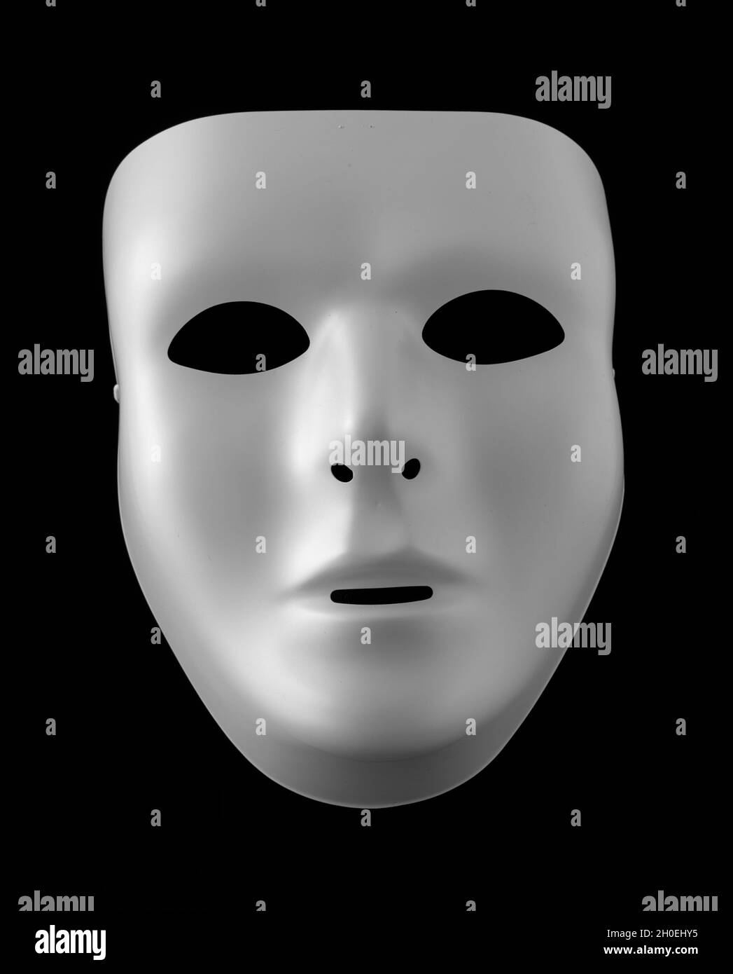 Maschera bianca vuota isolata contro sfondo nero Foto Stock