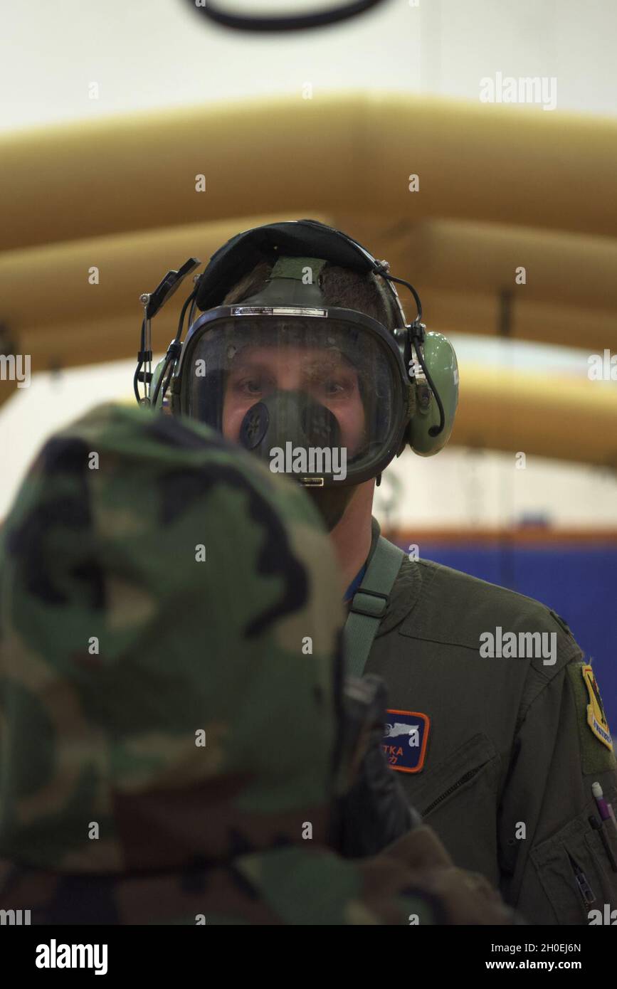 Nathan Setka, un responsabile della battaglia aerea del 961st Airborne Air Control Squadron, si allena per la corretta rimozione del MOPP (Mission Oriented Protective Posture) adattato per l'equipaggio di Kadena Air base, Giappone, 12 febbraio 2021. Le stazioni di decontaminazione utilizzano procedure di sicurezza come la rimozione di coperture esterne, guanti e stivali, nonché un picchiettino con guanti di carbone in caso di contaminazione. Foto Stock