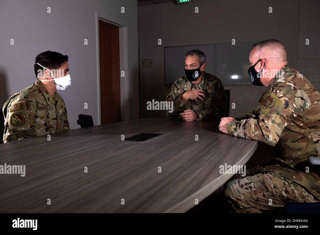 Kenneth Wilsbach, il centro del comandante delle forze aeree del Pacifico, parla con lo staff dell'aeronautica statunitense Sgt. Aaron Brock, a sinistra, un tecnico di fornitura assegnato al 673d Logistics Readiness Squadron, e U.S. Air Force Chief Master Sgt. David Wolfe, a destra, il capo di comando delle forze aeree del Pacifico, come parte di una serie di prevenzione del suicidio alla base congiunta Elmendorf-Richardson, Alaska, 13 febbraio 2021. La leadership di PACAF ha condotto un tour di immersione di JBER per conoscere il ruolo dell'installazione nella preparazione e nella difesa nell'Artico e come la base rimanga pronta per il futuro attraverso l'innovazione Foto Stock