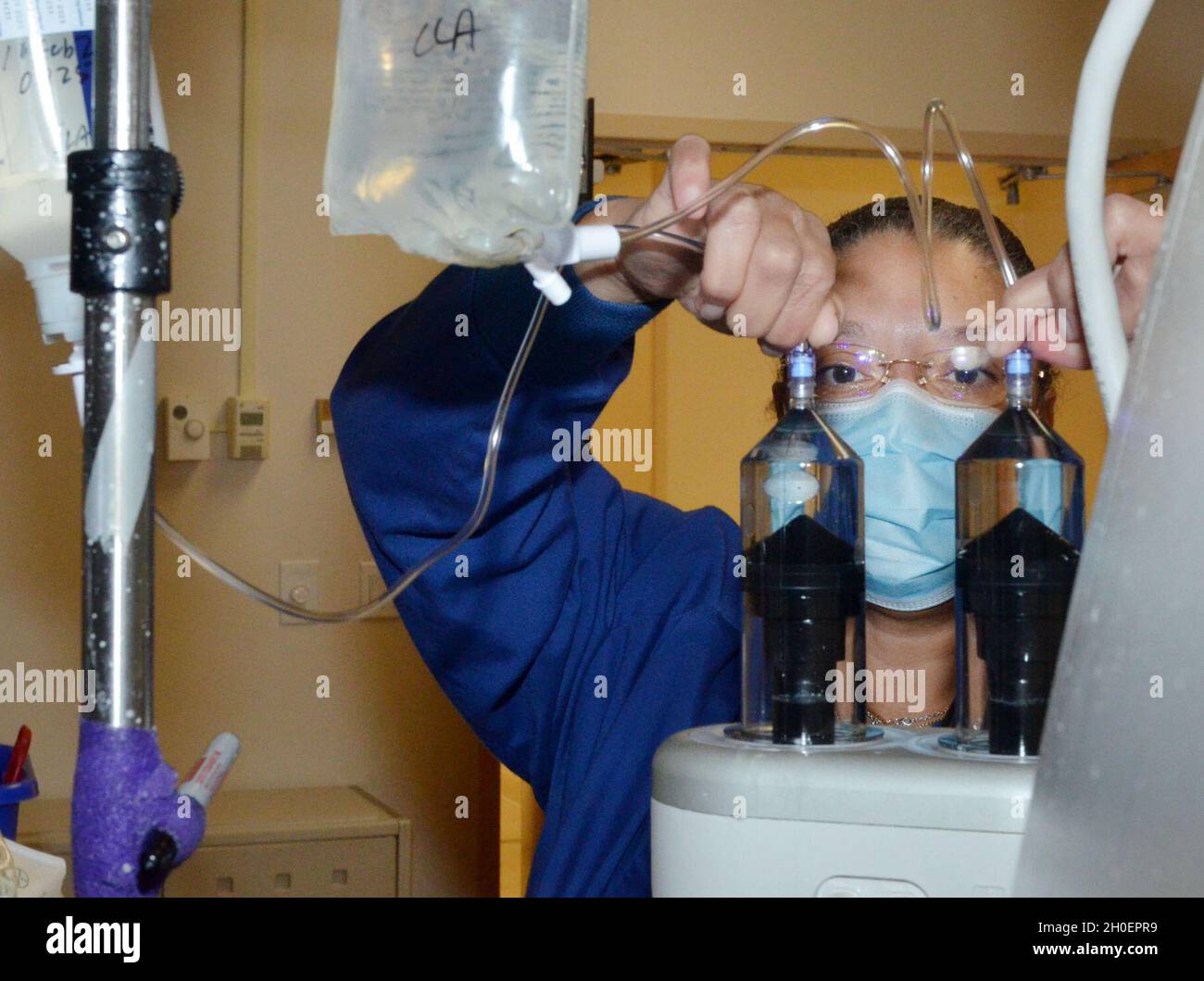 JACKSONVILLE, Florida (dal 16, 2021) - Christaline Antoine, un tecnico di tomografia computerizzata presso il Naval Hospital di Jacksonville, collega la soluzione salina in preparazione di una scansione TC. Antoine, nativo di San Giovanni, Isole Vergini, afferma: "Il mio lavoro sta svolgendo un buon studio in modo che i medici possano identificare ed escludere i problemi". Foto Stock