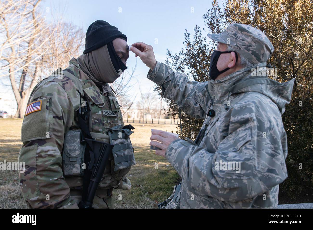 SPC dell'esercito degli Stati Uniti. Demetrie Churchwell, 1436° Engineer Company, 507° Engineer Battaglione, Michigan National Guard, riceve ceneri da Air Force Lt. Colon. Brian J. McNamara, un cappellano con la 106° Rescue Wing, New York National Guard, durante il turno del Mercoledì delle Ceneri presso il Campidoglio degli Stati Uniti, a Washington, D.C., 17 febbraio 2021. La Guardia Nazionale è stata invitata a continuare a sostenere le forze dell'ordine federali con sicurezza, comunicazioni, evacuazione medica, logistica e supporto per la sicurezza alle agenzie statali, distrettuali e federali fino a metà marzo. Foto Stock