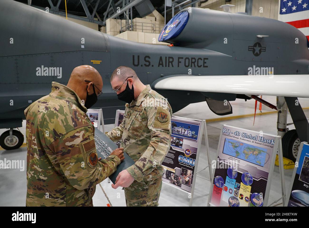 Capo dello staff dell'Air Force Gen. Charles Q. Brown Jr., a sinistra, firma un pannello offerto da Tech. SGT. Richard Waldon, 319th Aircraft Maintenance Squadron Aircraft FUEL Systems Section Chief, at Grand Forks Air Force base, N.D., 17 febbraio 2021. Brown ha ricevuto un brief da Waldon, che ha condiviso i dettagli degli aerei per la RQ-4 Global Hawk e il suo ruolo nella missione di intelligence, sorveglianza e ricognizione della 319a ala del Rinascimento. Foto Stock