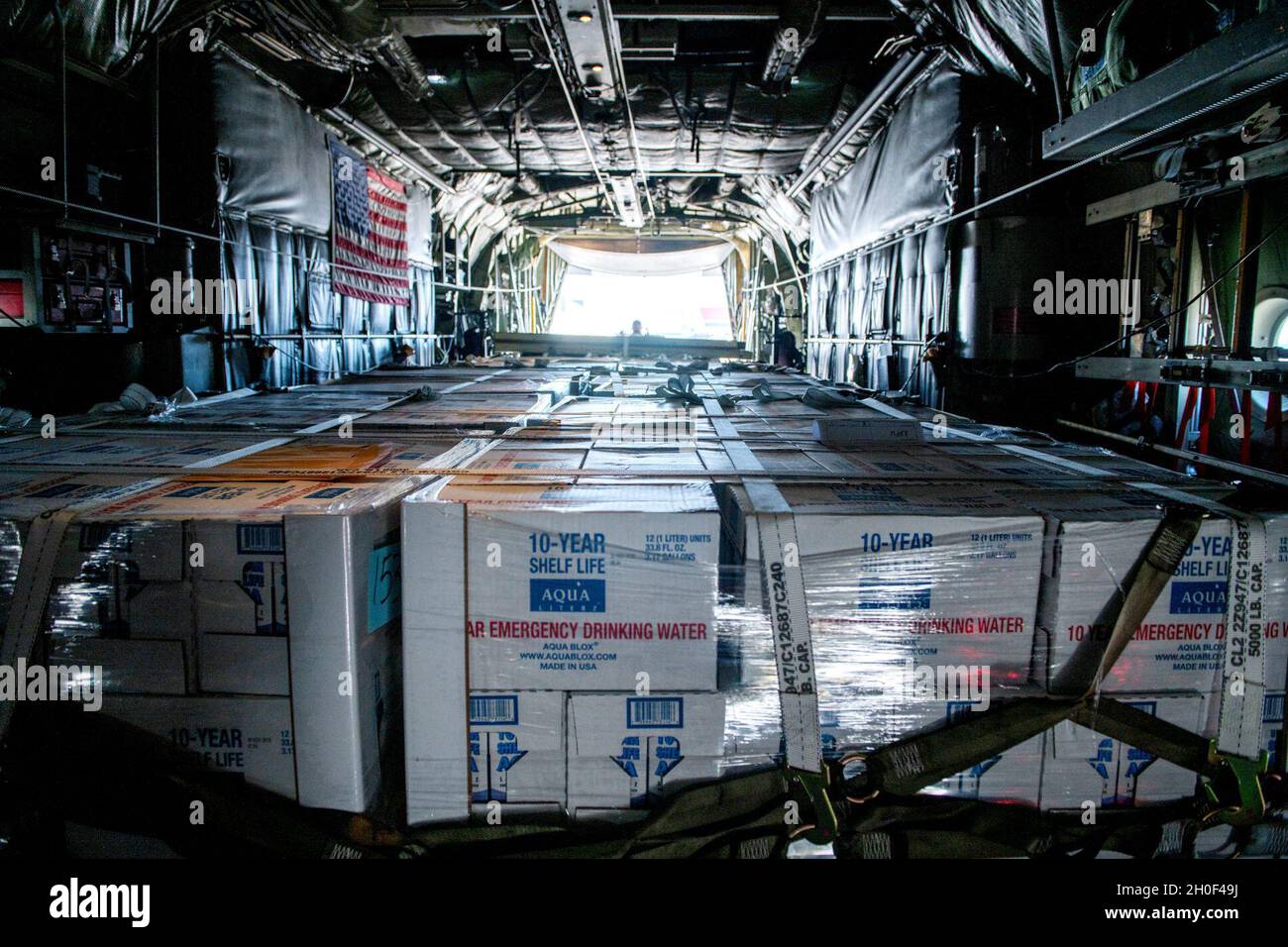 I pallet di acqua in bottiglia attendono di essere scaricati da un C-130 dalla 136a Ala Airlift, Texas Air National Guard, ft. Worth, Texas. Il cinquantaduesimo Squadrone di preparazione logistica ha assistito con il coordinamento e lo scarico di più di 150,000 libbre di acqua in bottiglia portata in aereo a Kelly Field per essere distribuita alla città di San Antonio. Foto Stock