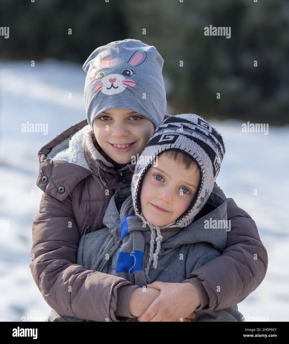 Disturbarti e sorella che si agguantano sulla neve nel parco Foto Stock