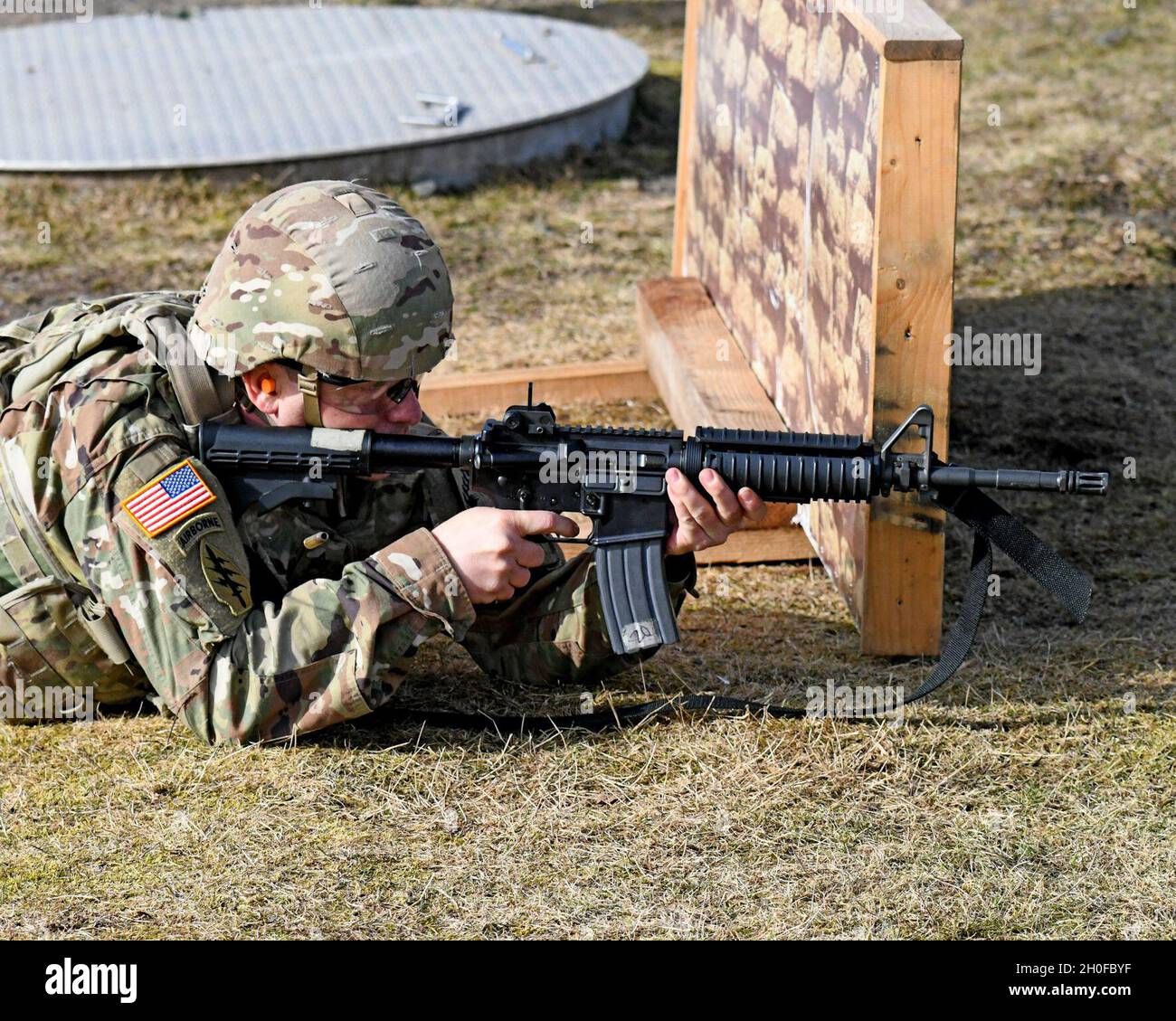 SGT. Prima classe Justin S. Rorex con 1 ° battaglione, 214 reggimento di aviazione, 12 ° combattimento brigata di aviazione, 'Wings of Victory,' durante un esercizio di fuoco dal vivo con M4 Carbine, subito dopo il fuoco, con un caso espulso a mezz'aria. Baumholder Maneuvre Training Area, Range 21, Germania 24 febbraio 2021. Foto Stock