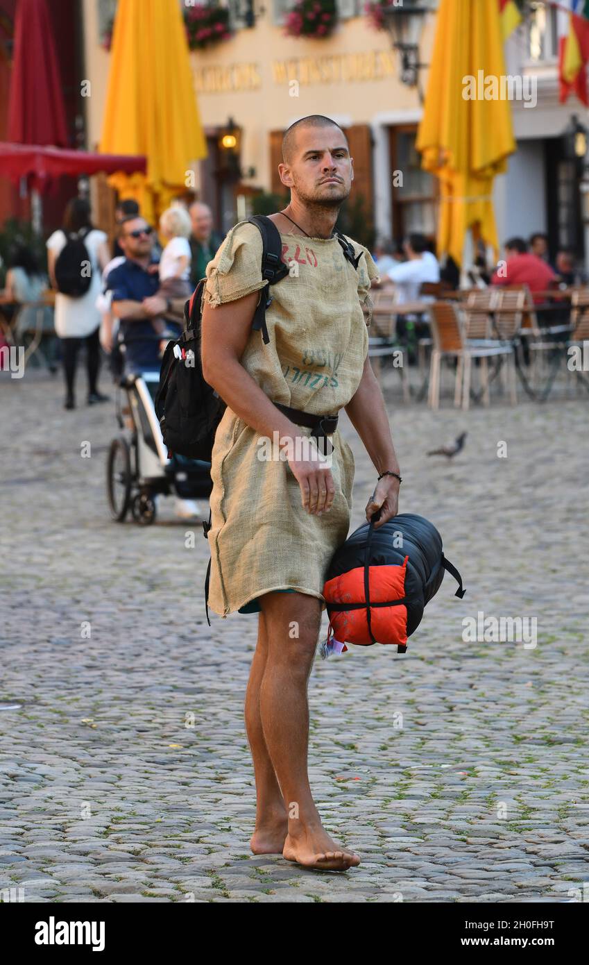 Uomo che indossa abiti in sackcloth su strada acciottolata a Friburgo in Germania. Flamboyant, stilismo, elegante, Foto Stock