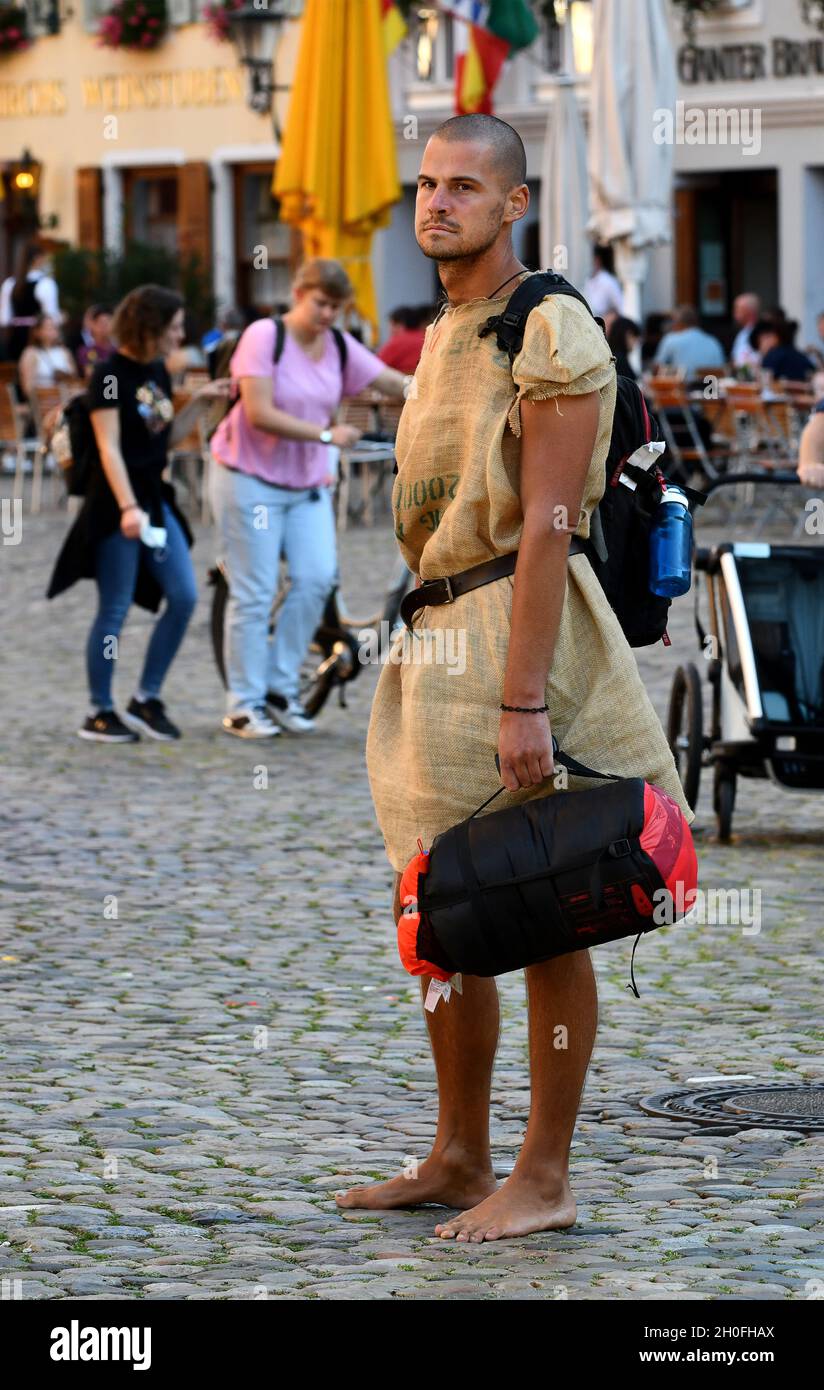 Uomo che indossa abiti in sackcloth su strada acciottolata a Friburgo in Germania. Flamboyant, stilismo, elegante, Foto Stock