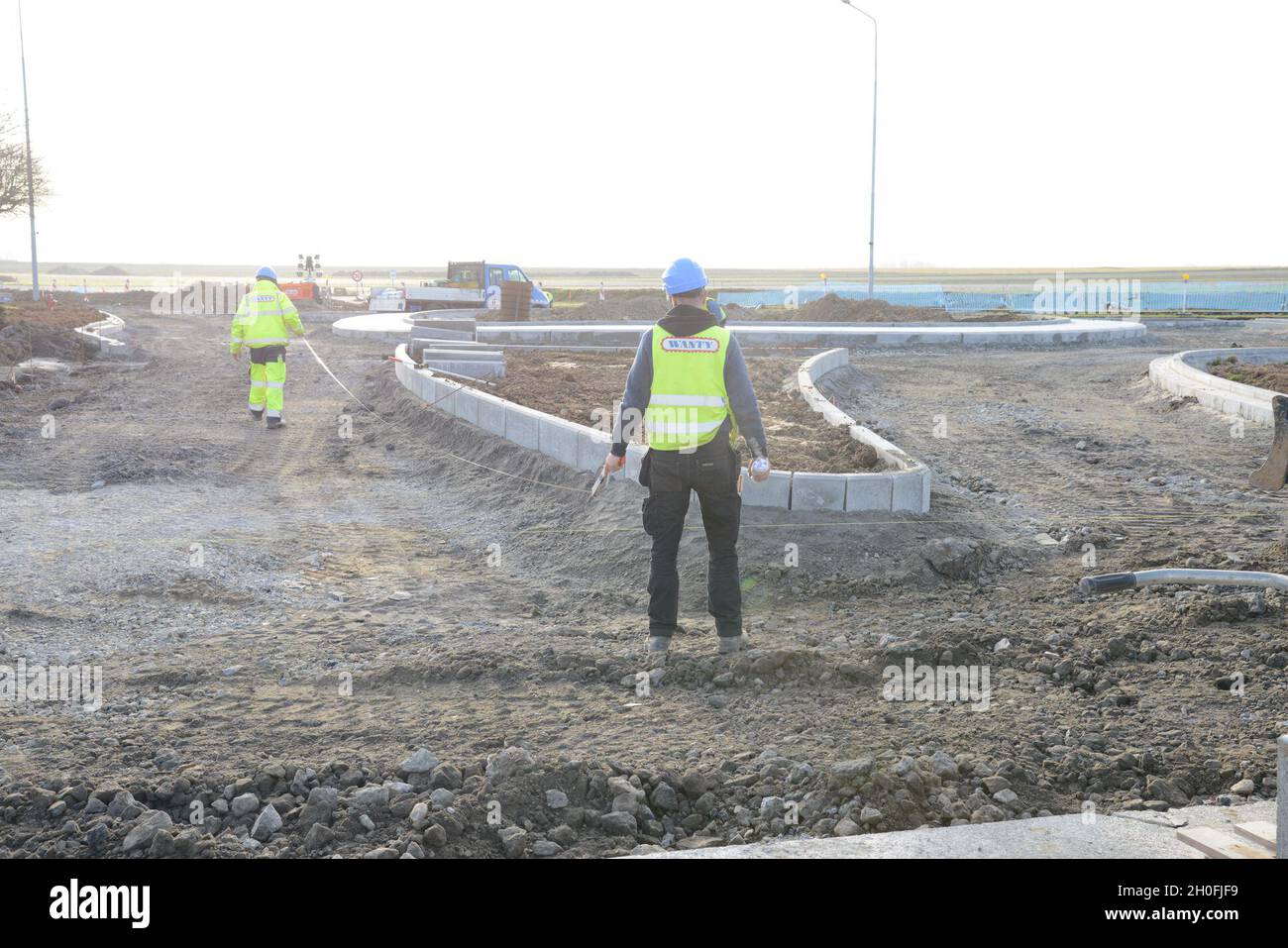 Gli appaltatori con la ditta di costruzioni belga WANTY verificano le dimensioni della disposizione durante la costruzione di un cerchio di traffico sulla base aerea di Chièvres, Belgio, 25 febbraio 2021. Foto Stock